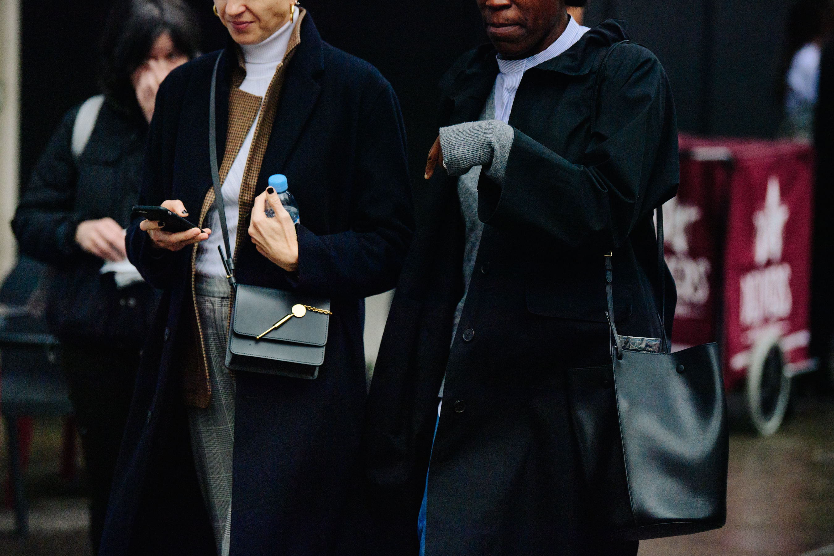 Two women wearing dark coats
