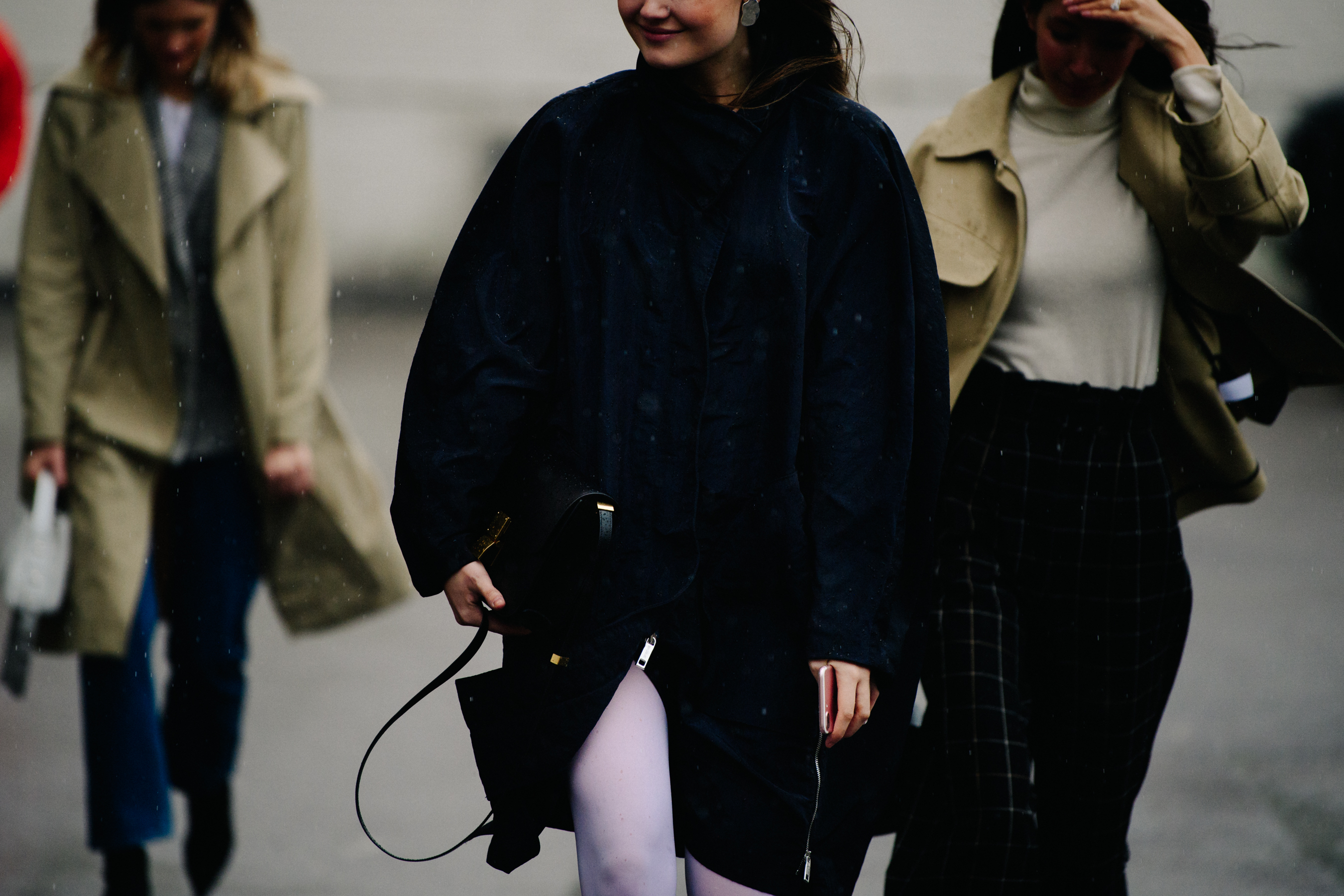 Three women wearing long coats