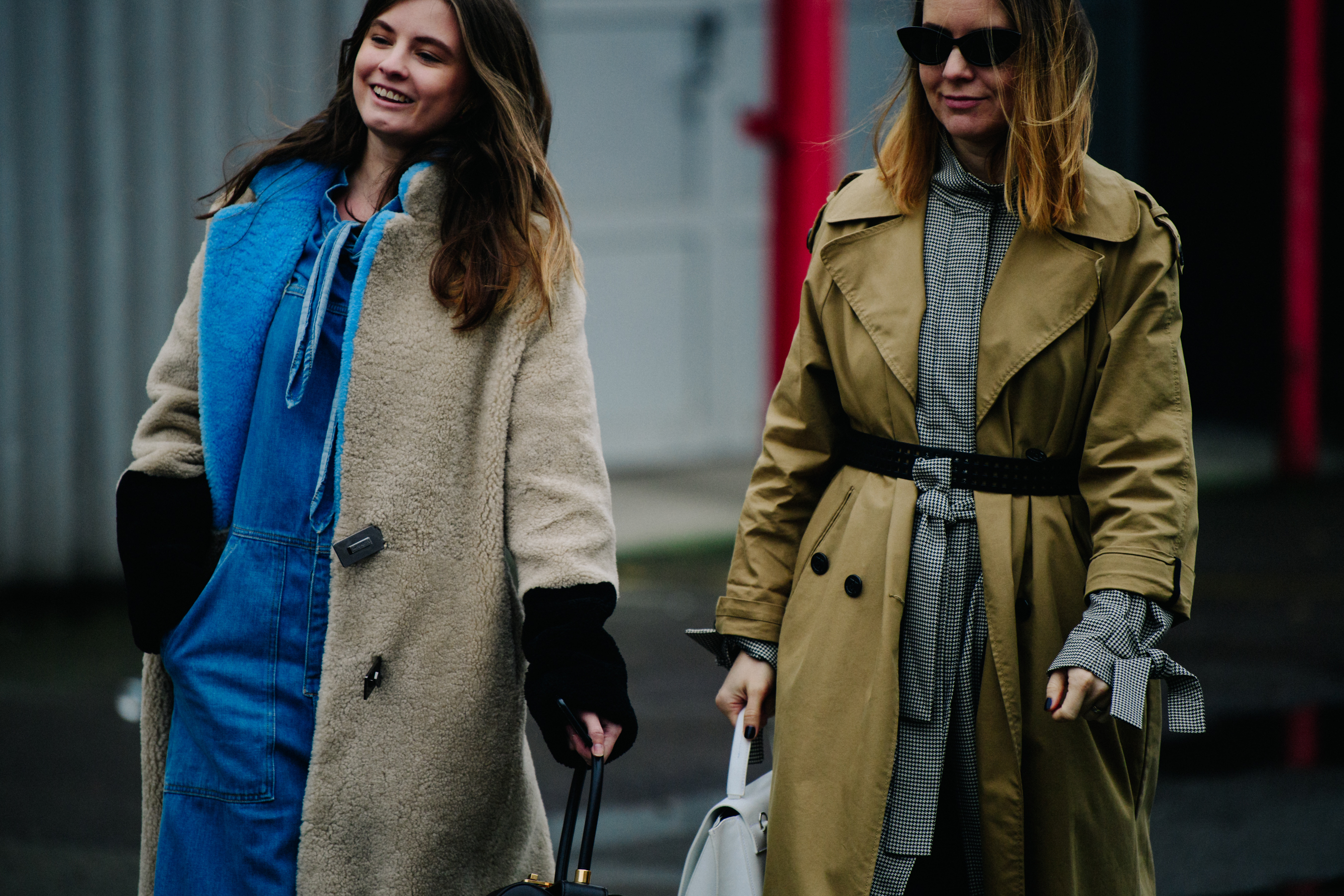 Two women wearing light colour coats