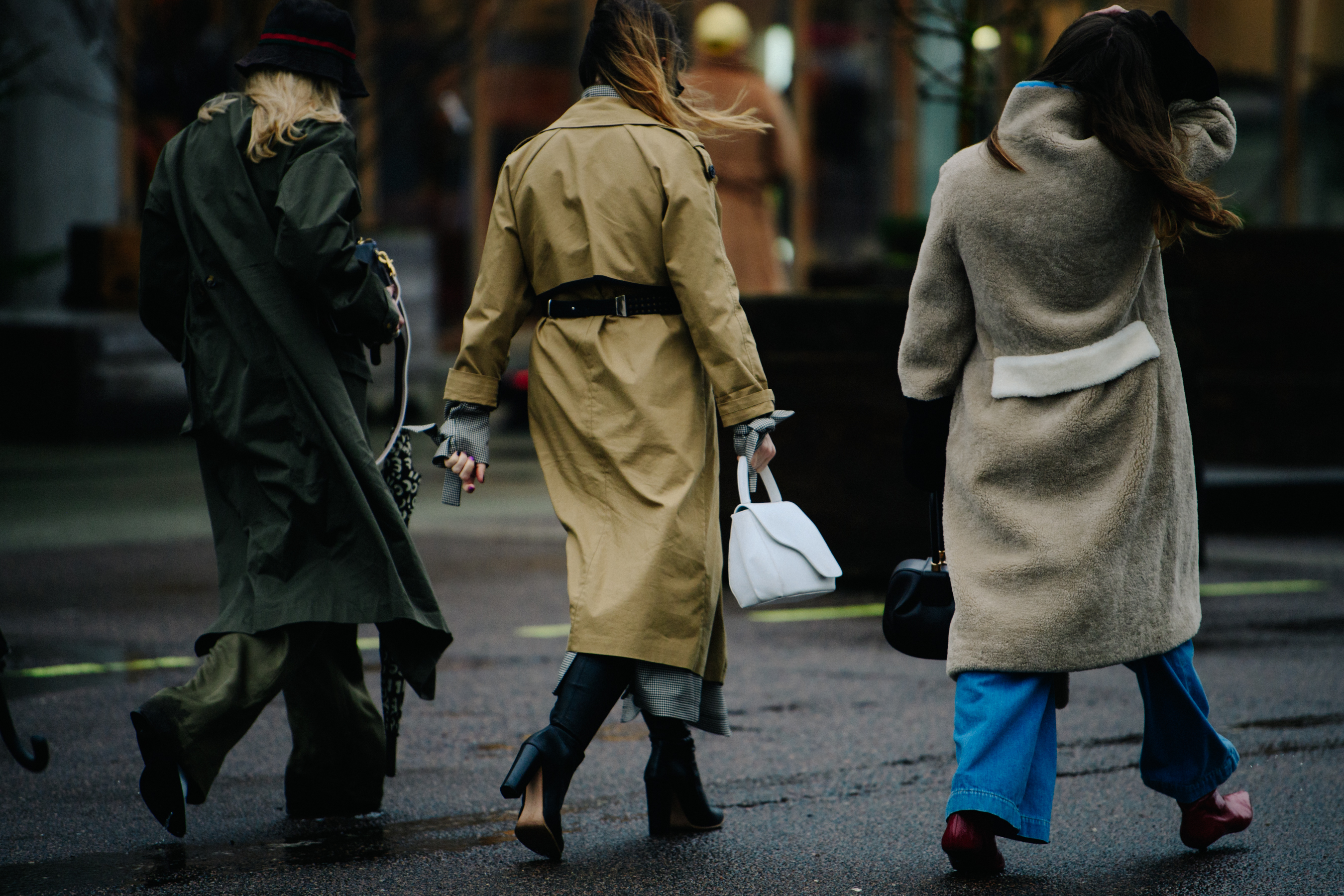 Three women wearing long coats