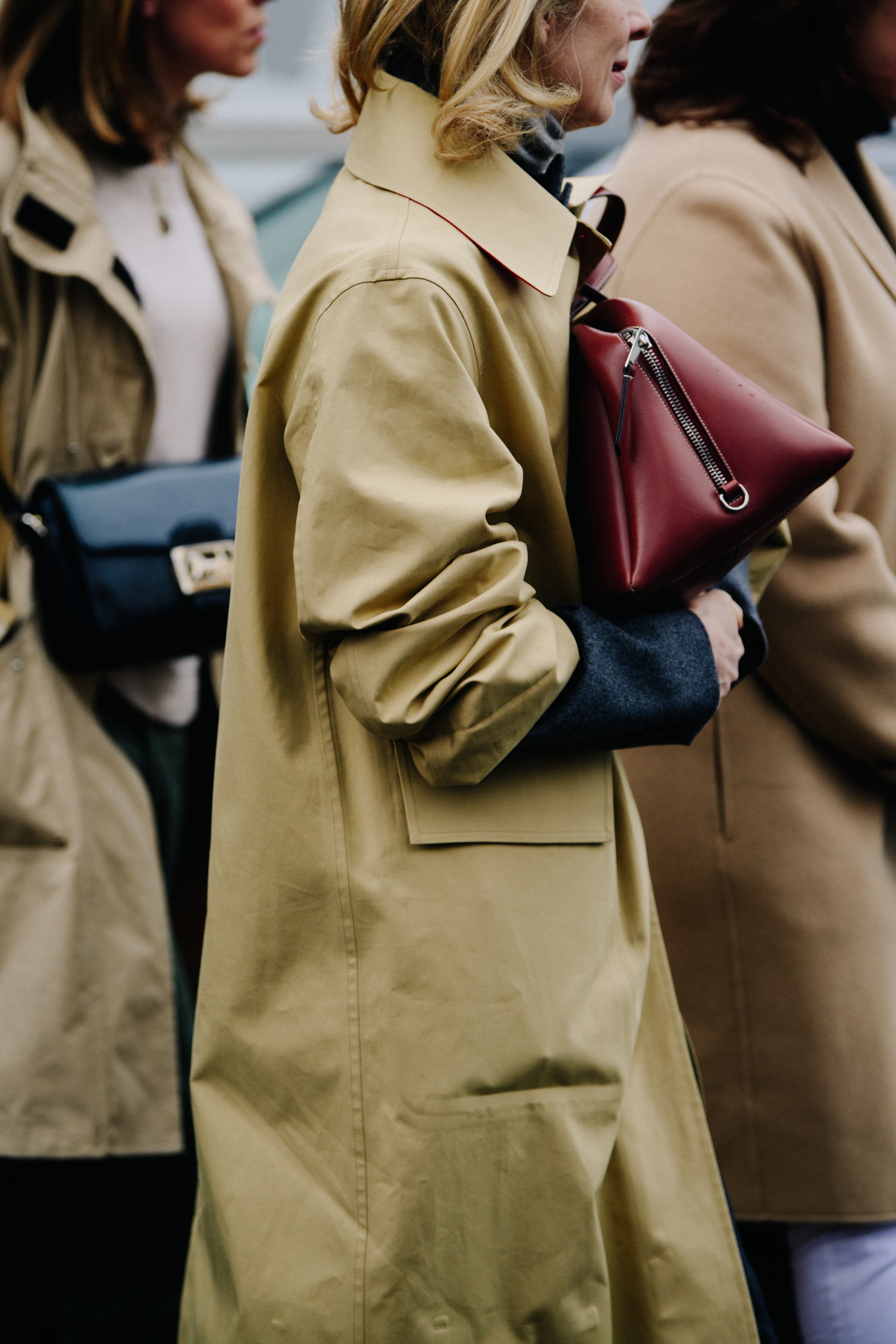 Three people wearing tan coats