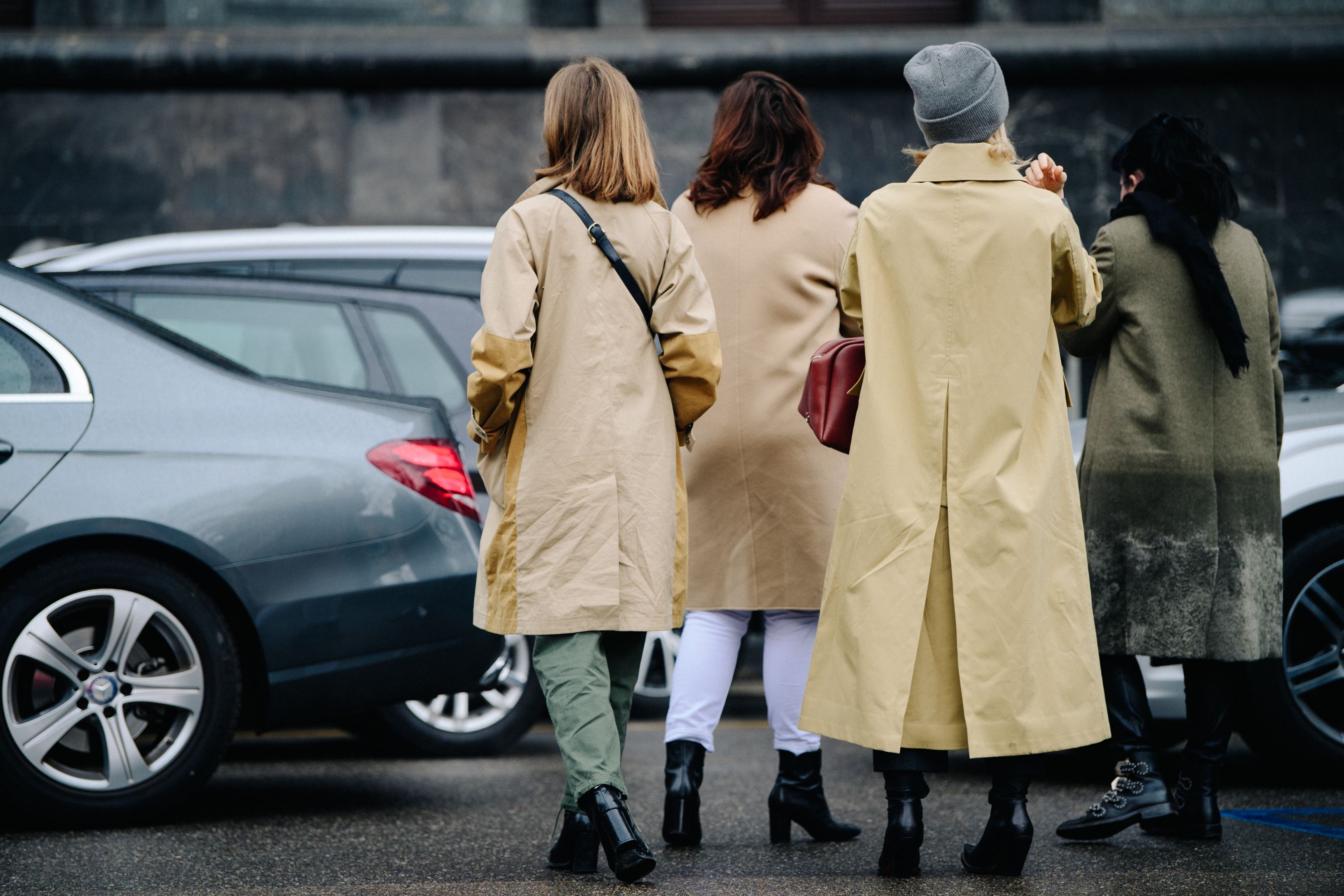 Three women wearing tan coats