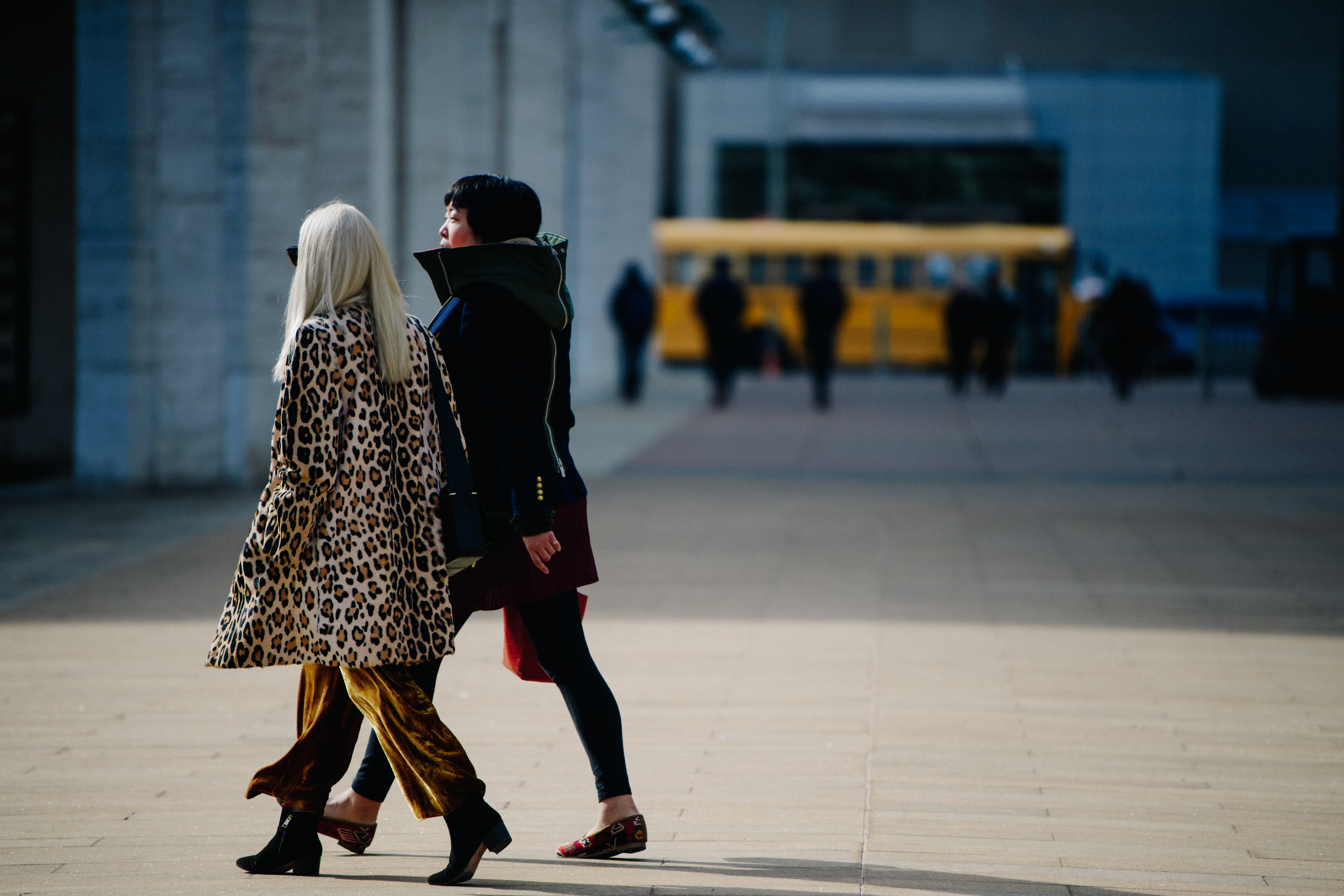 Two women wearing long coats