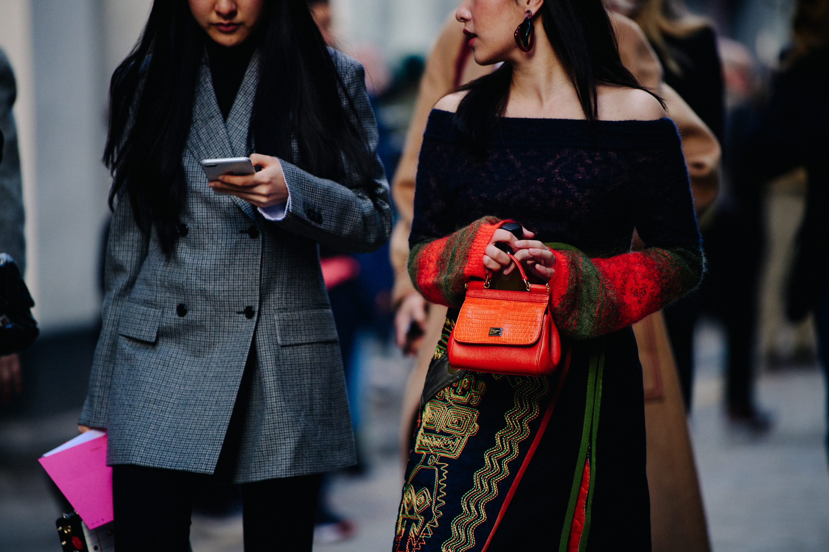 Two women carrying colourful bags