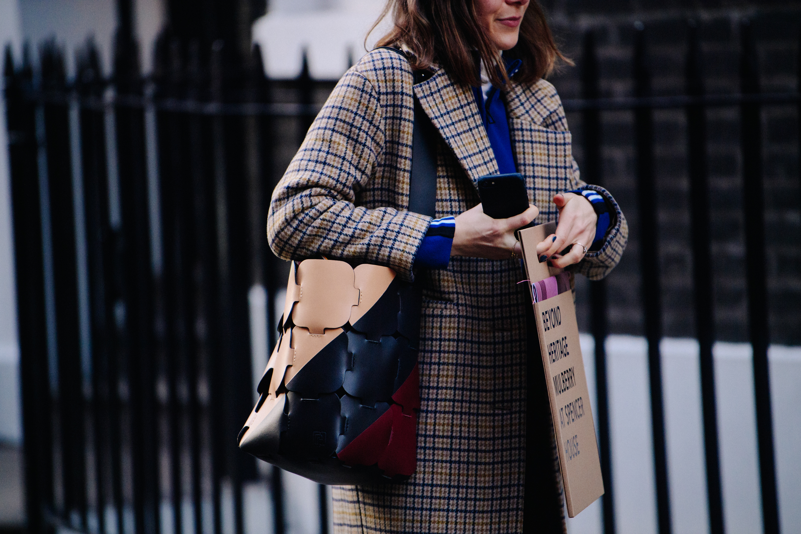 Woman carrying black and tan leather bag