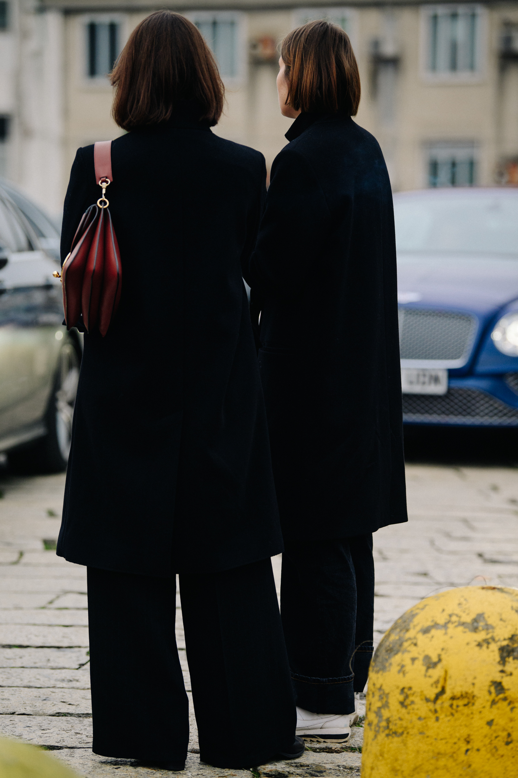 Two women wearing black coats