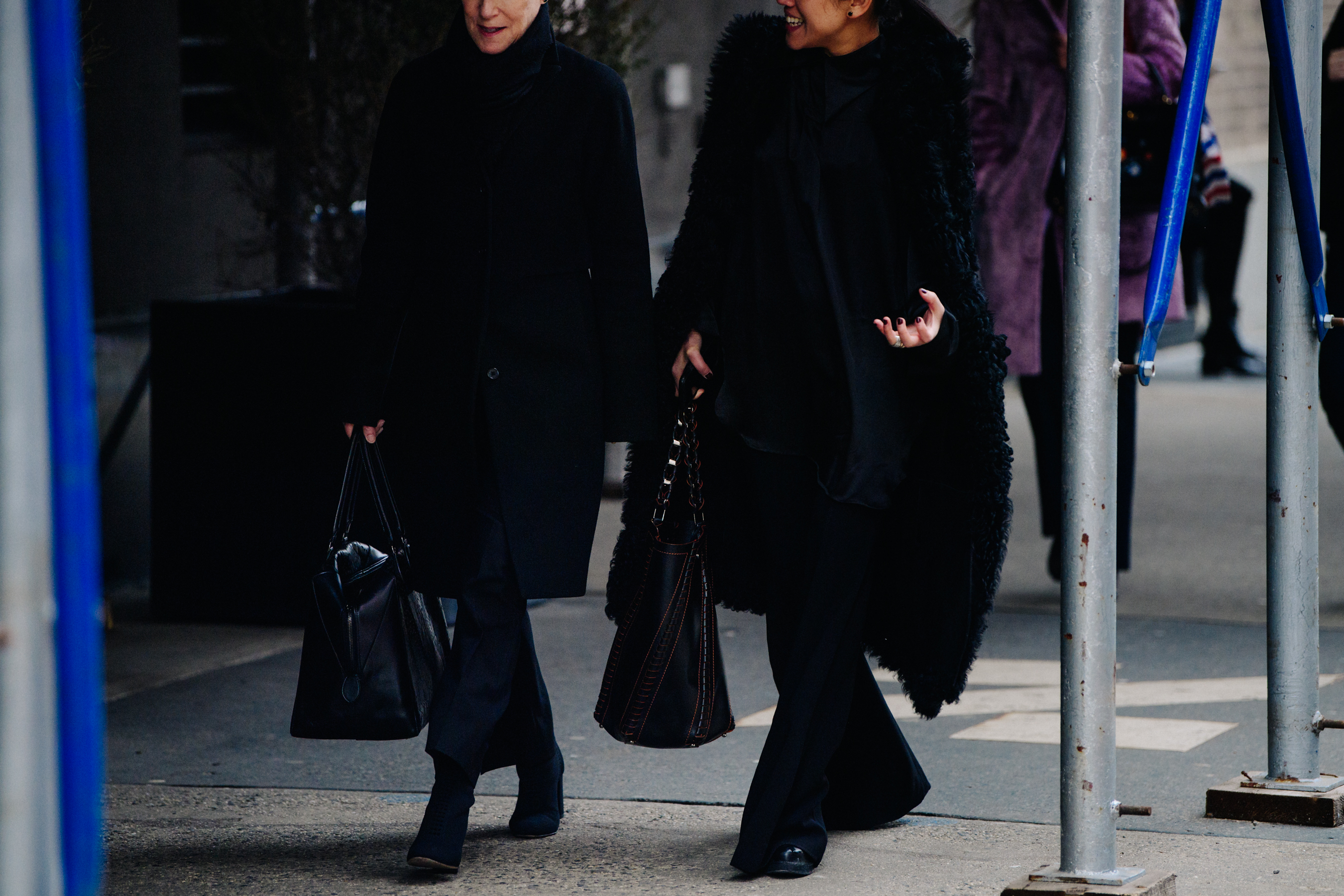 Two women wearing black outfits