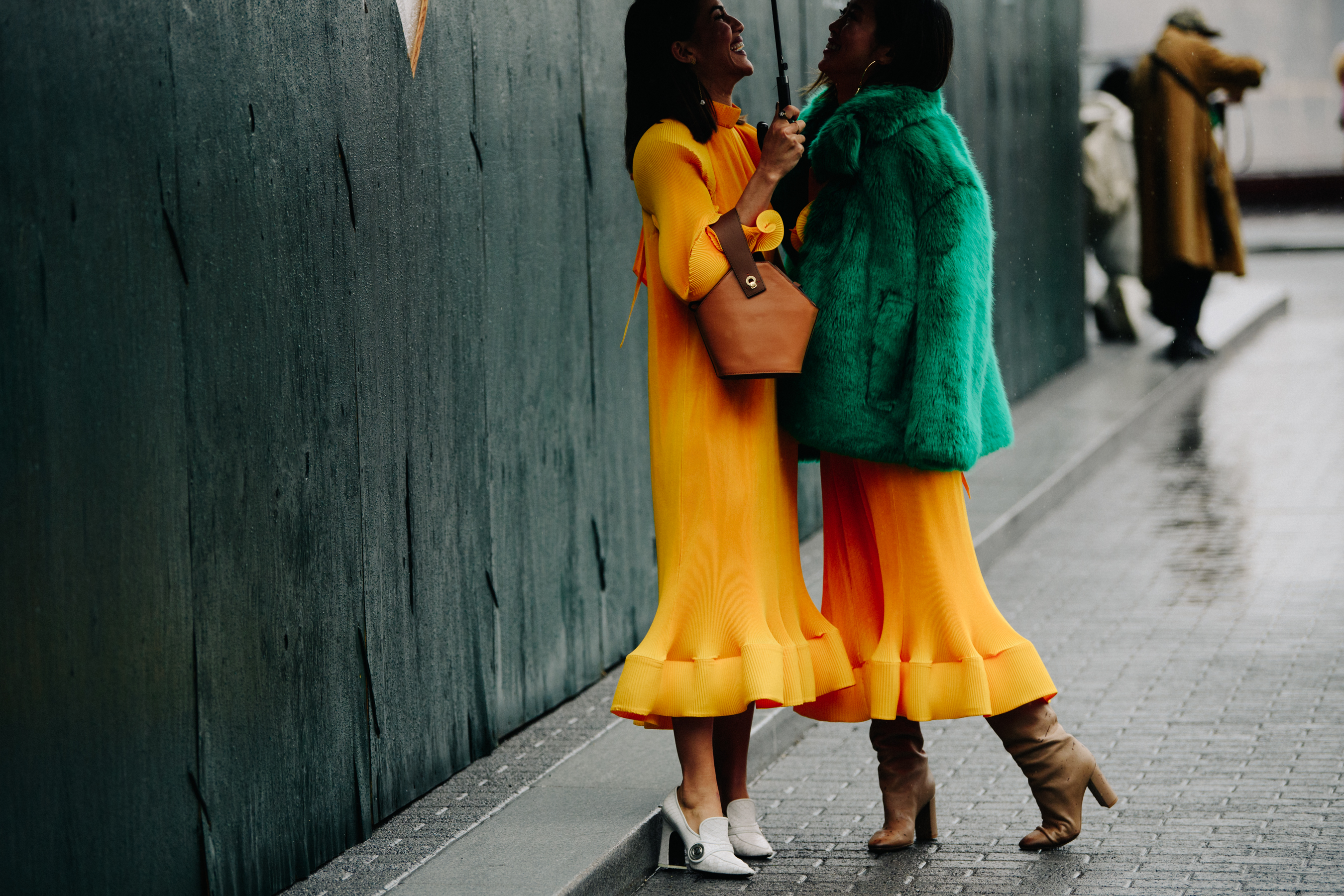 Two women wearing matching yellow dresses