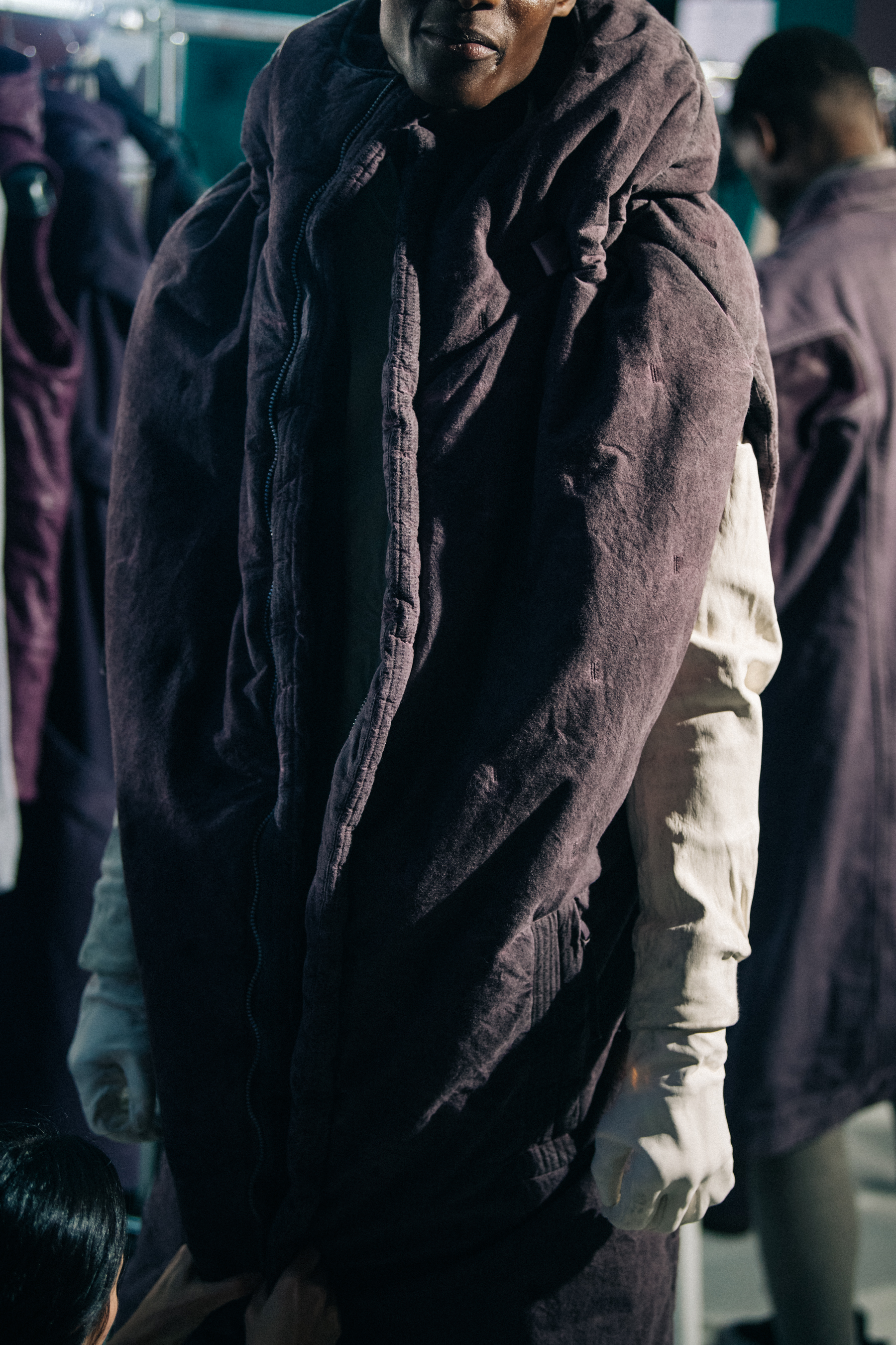 Model wearing grey and purple backstage