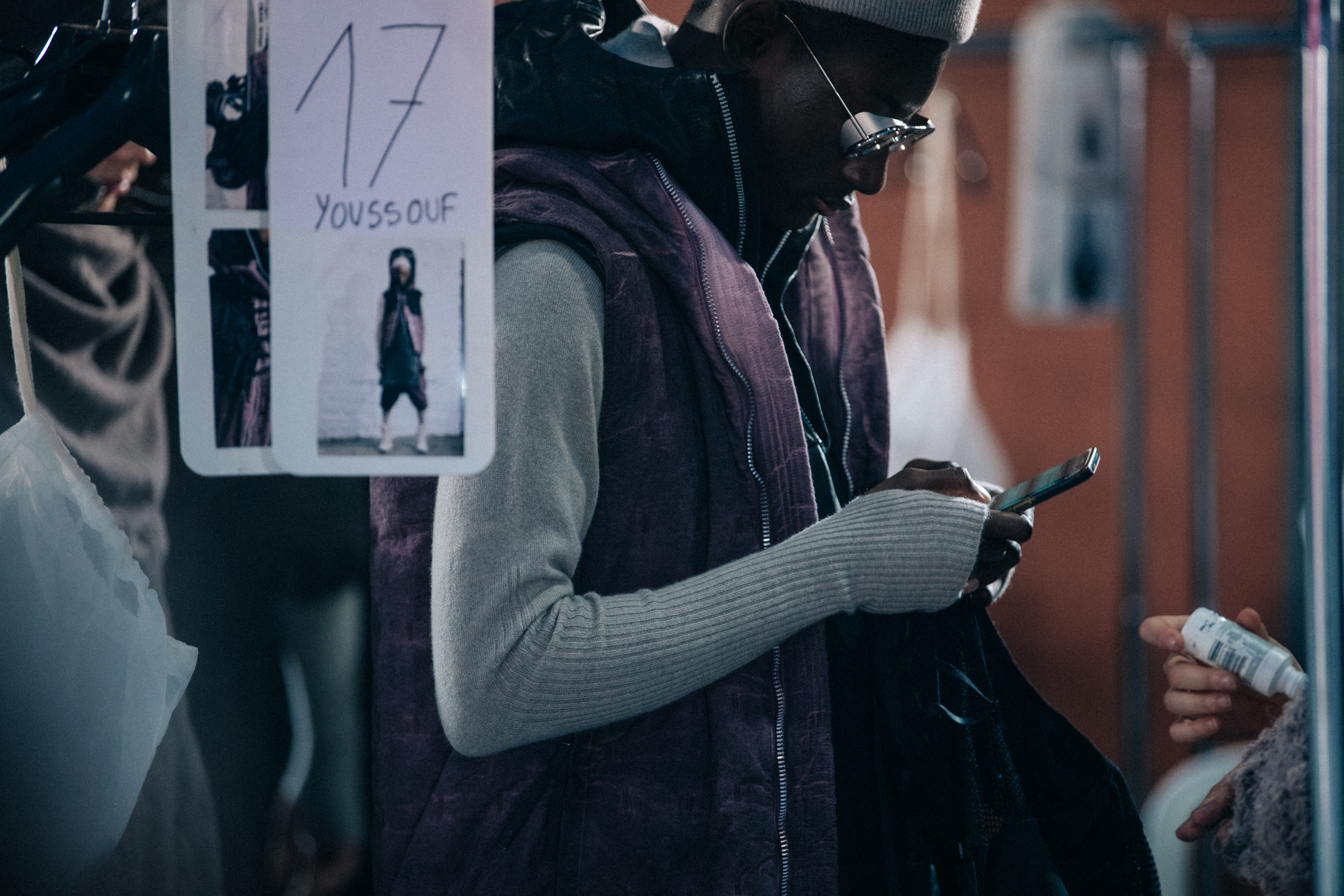 Model wearing grey and purple backstage