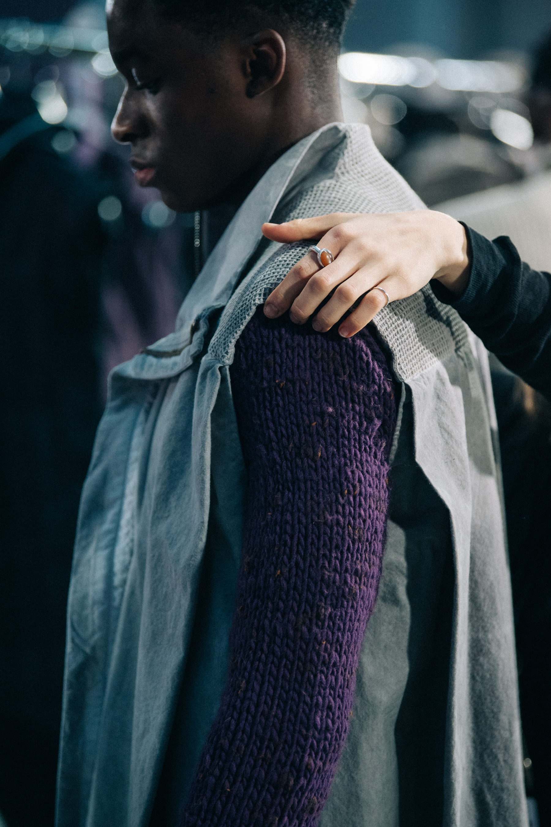 Model wearing grey and purple backstage