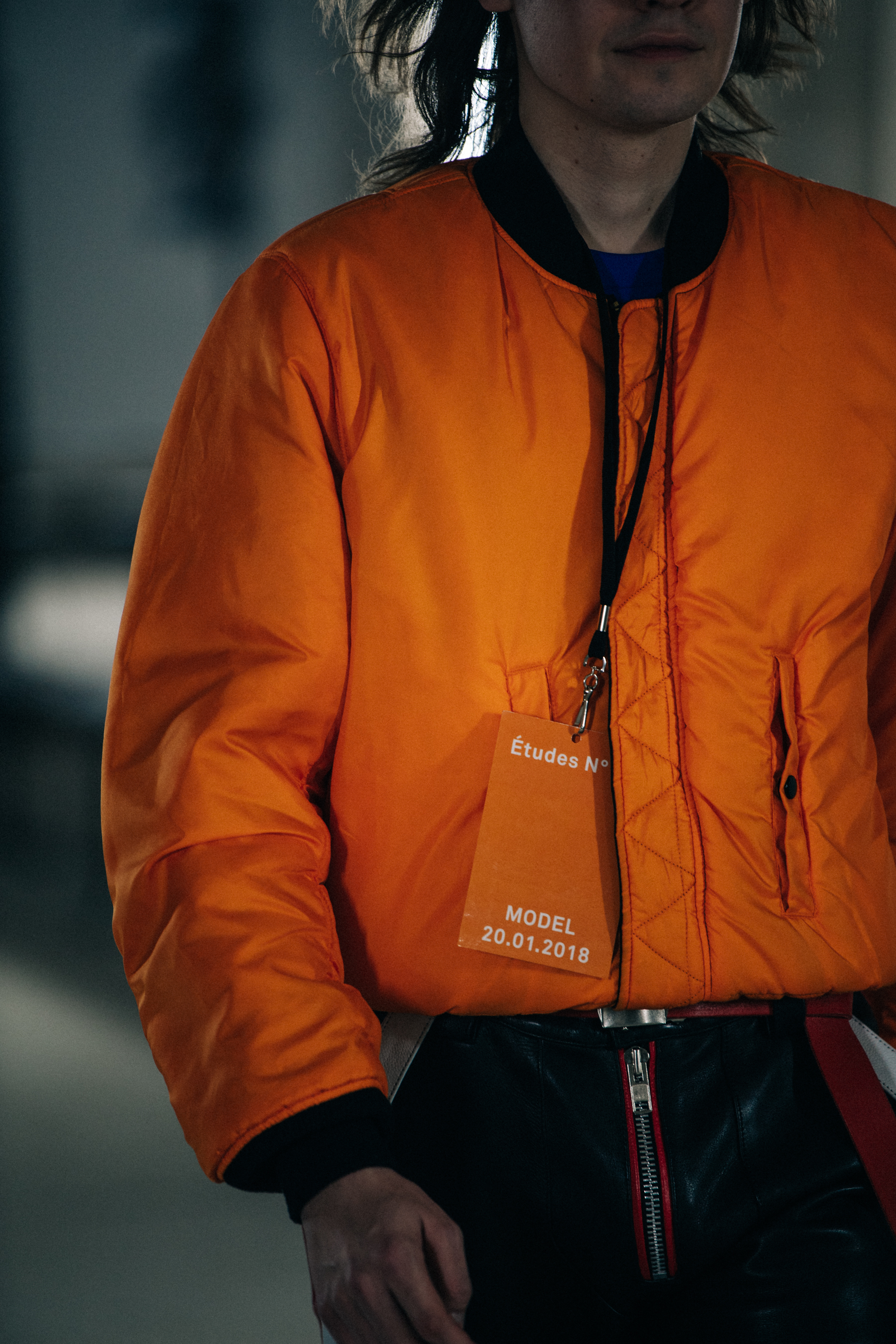 Model wearing orange backstage at Etudes Studio