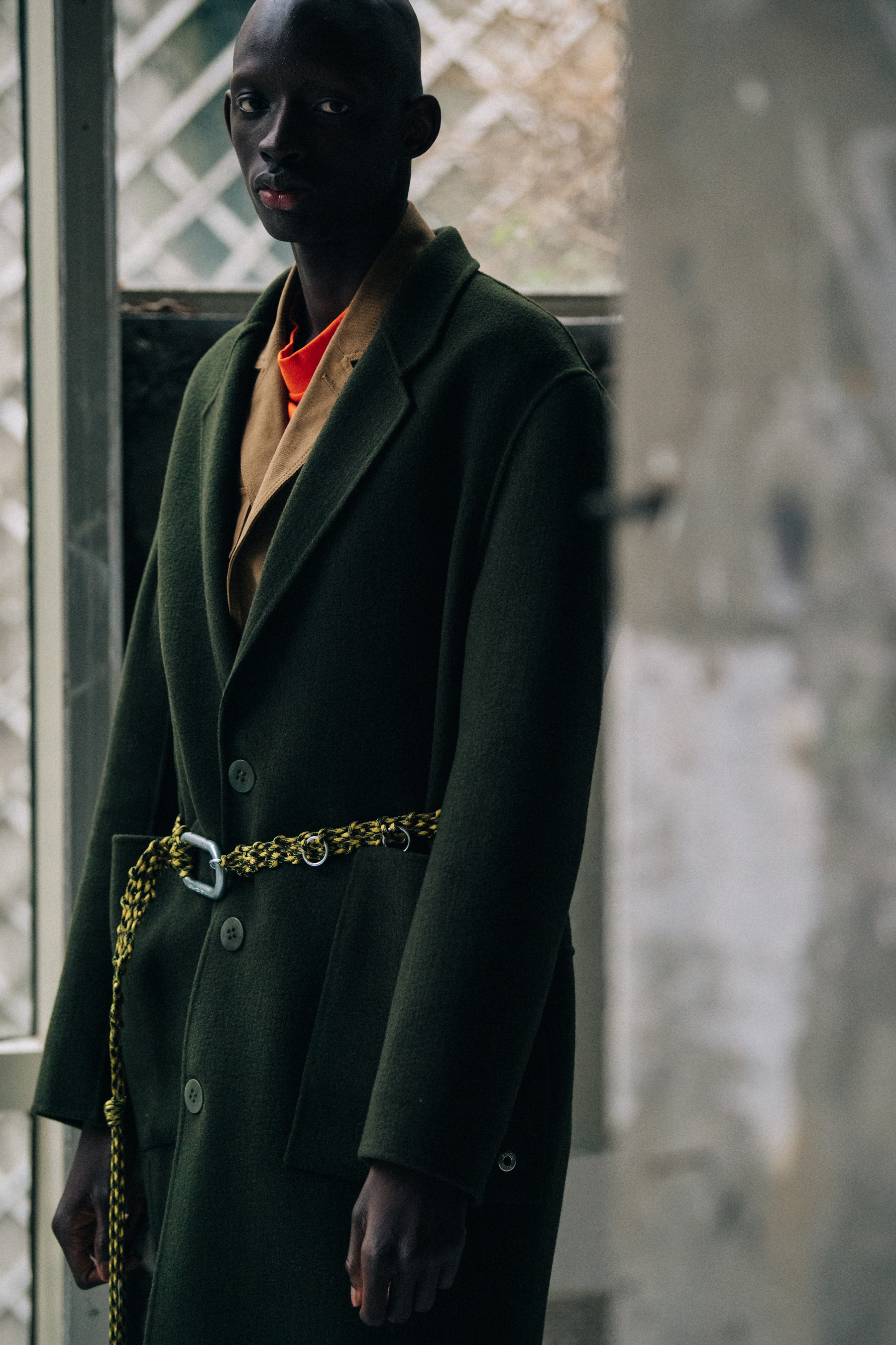 Model wearing green belted coat