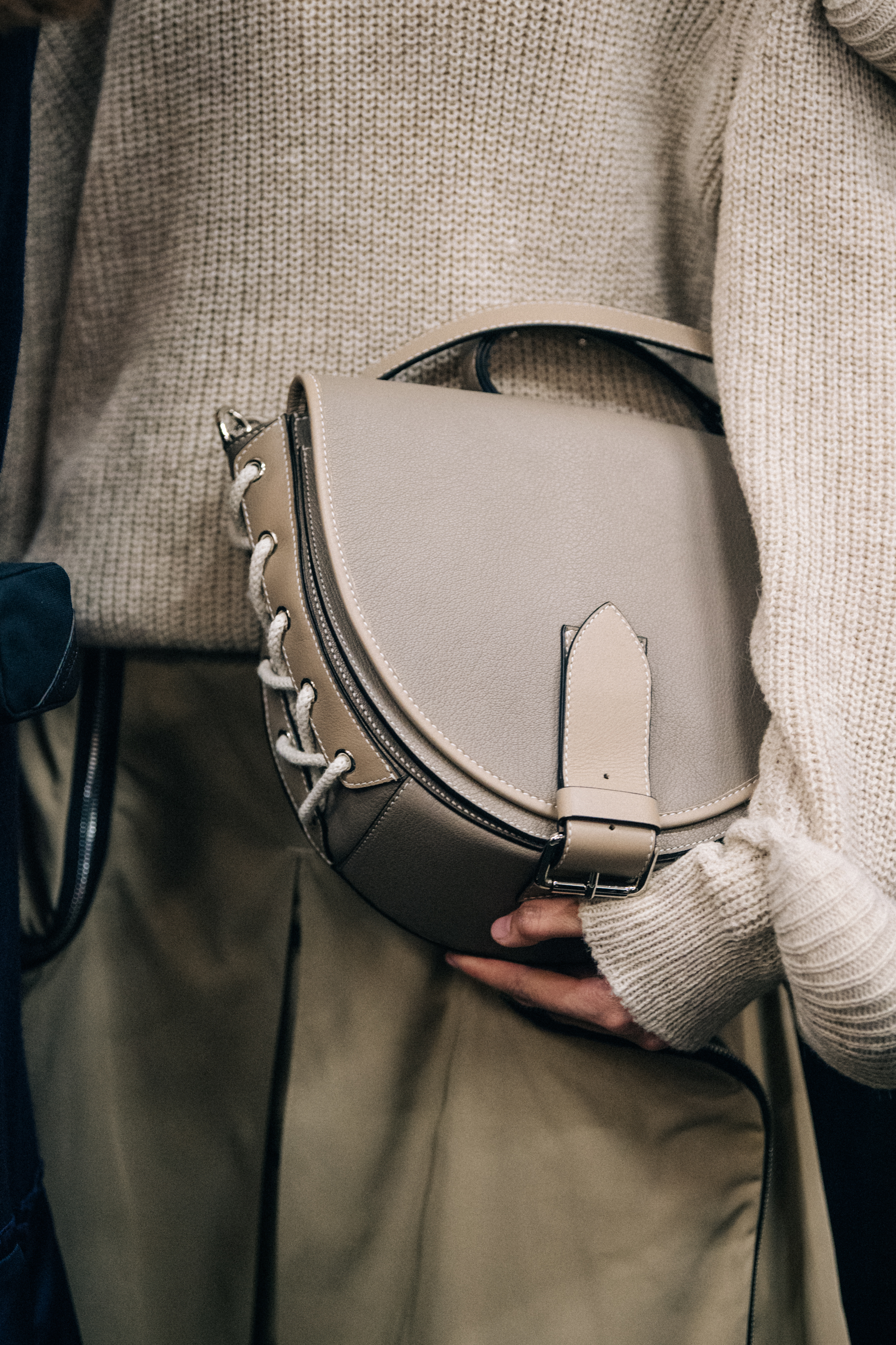 Model holding brown leather bag