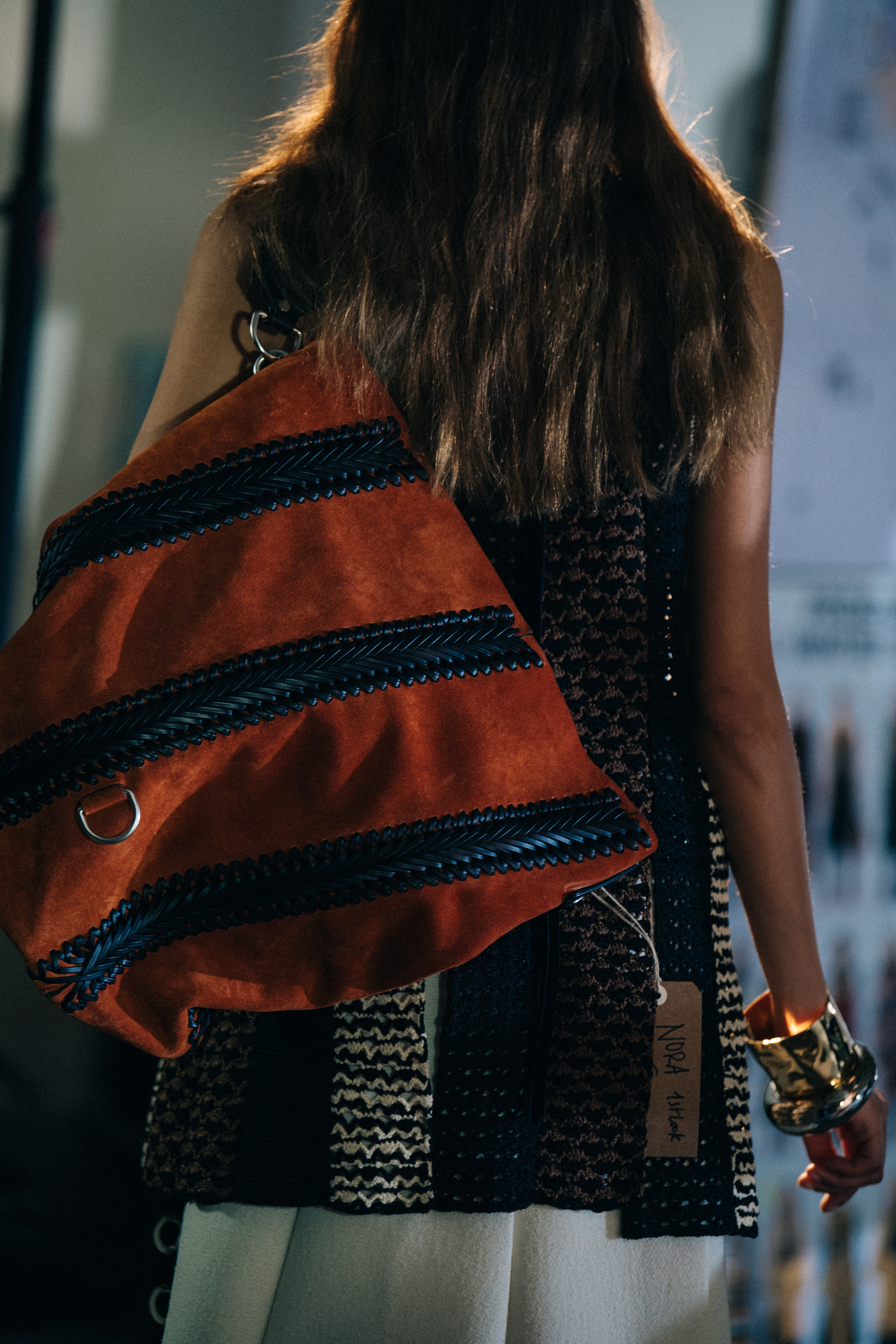 Model wearing dark tan bag