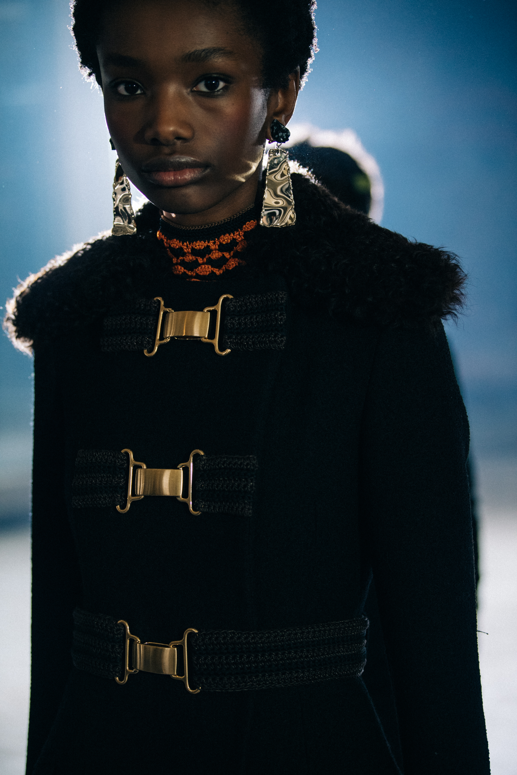Model wearing black fur lined coat