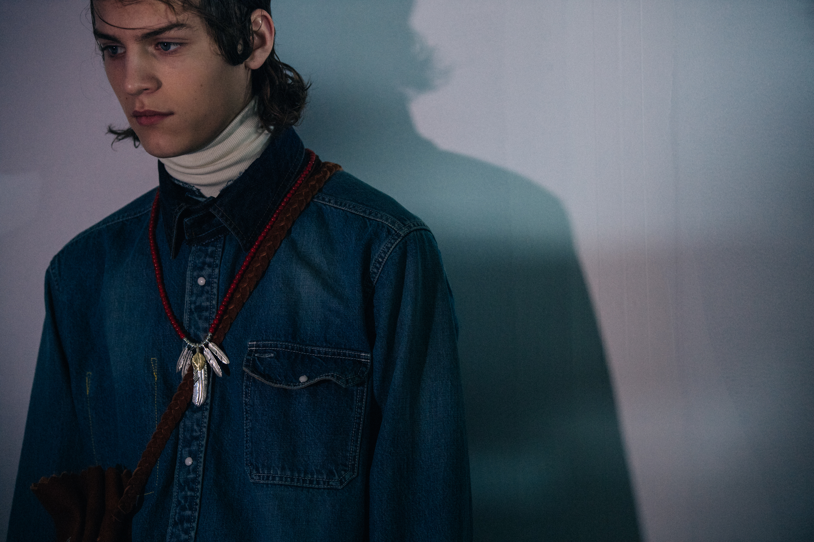 Model wearing denim shirt at Sacai