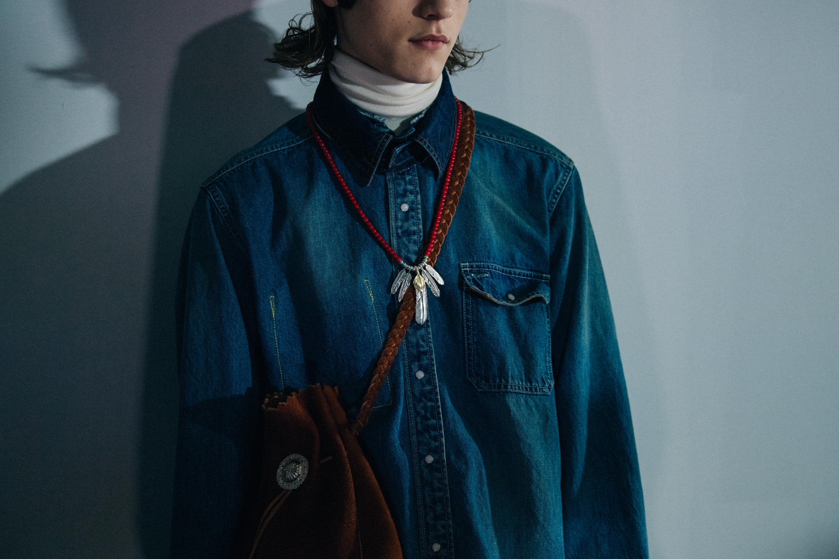 Model wearing denim shirt at Sacai