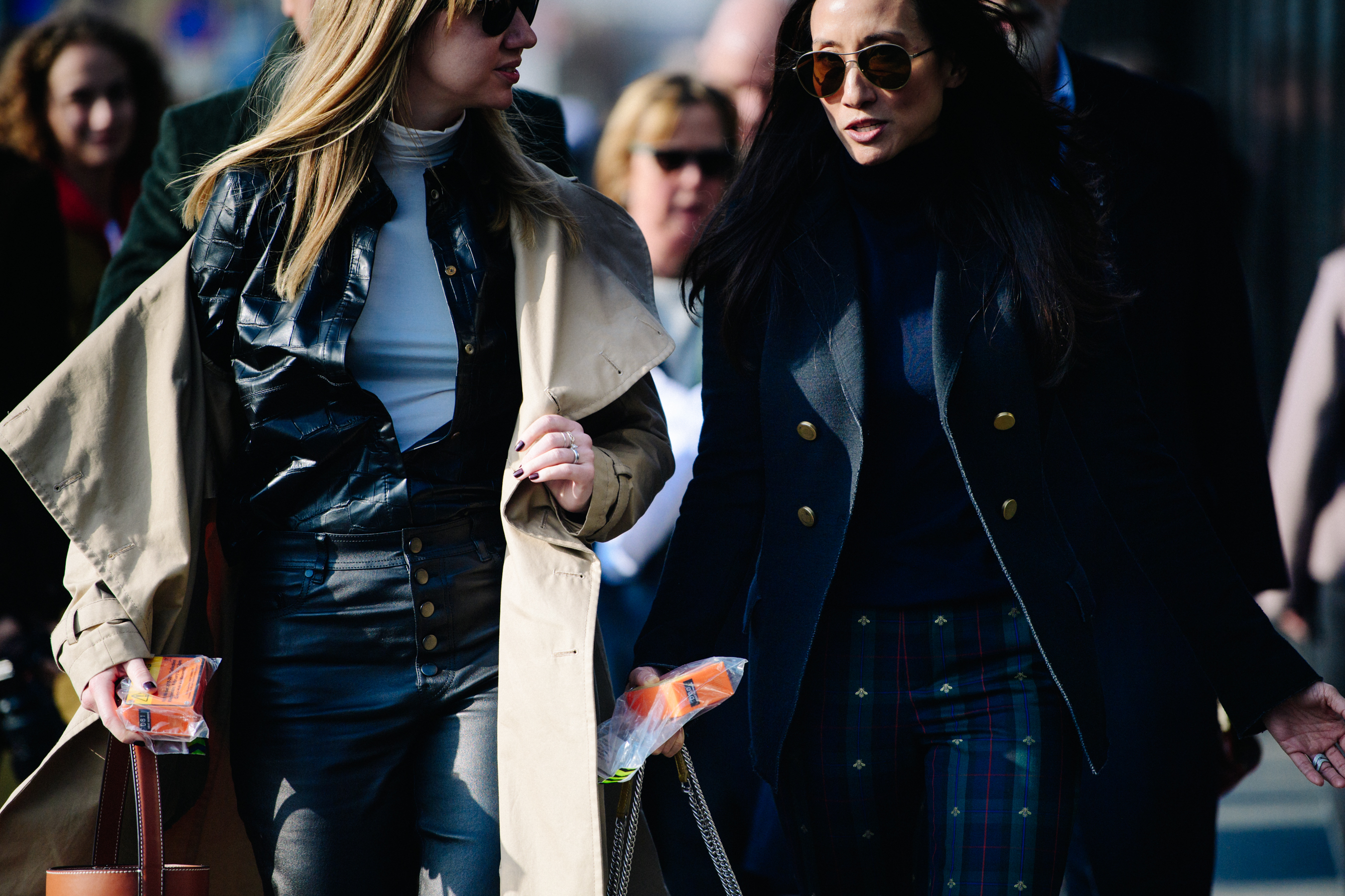Two women wearing long coats