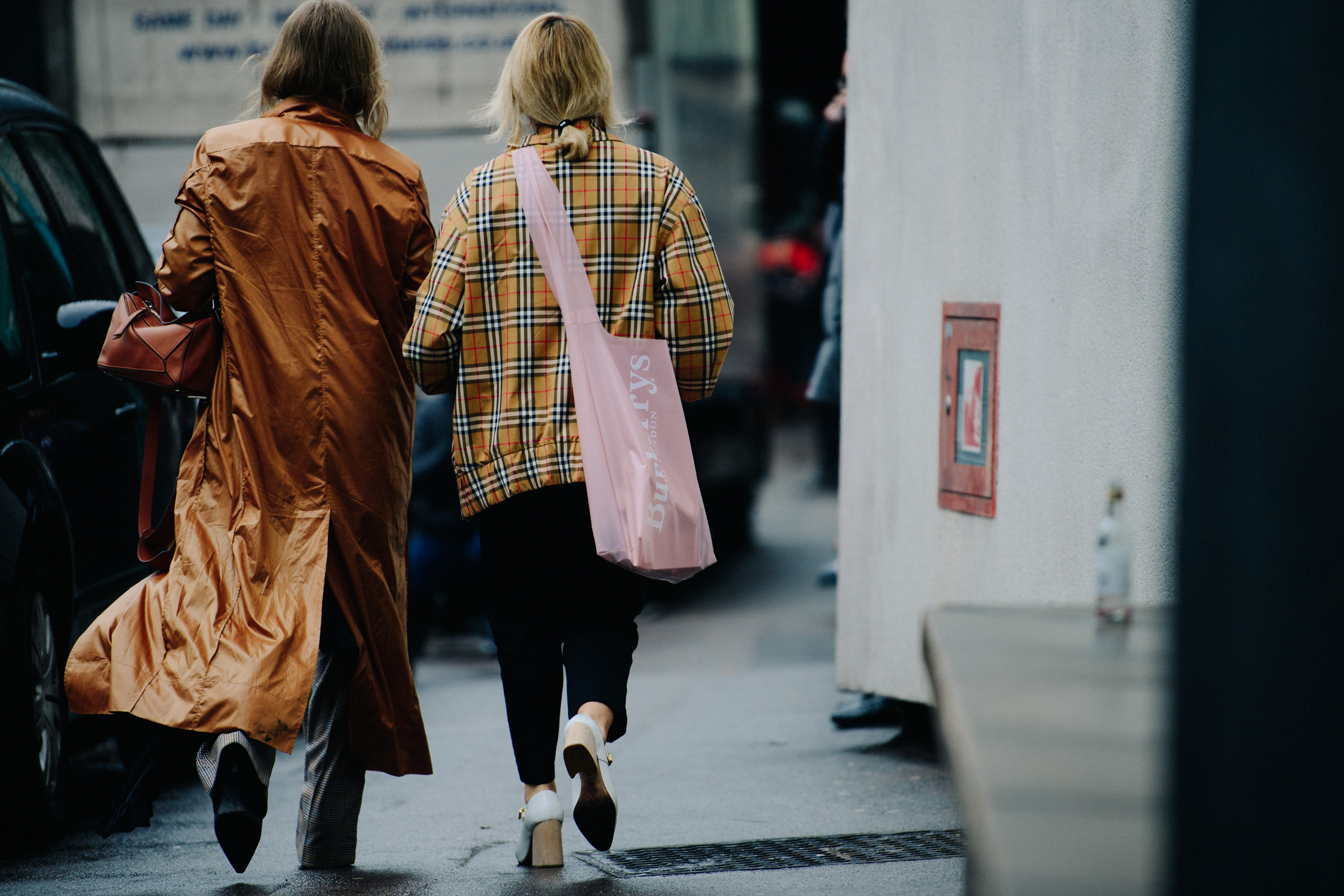 Two women wearing brown coats