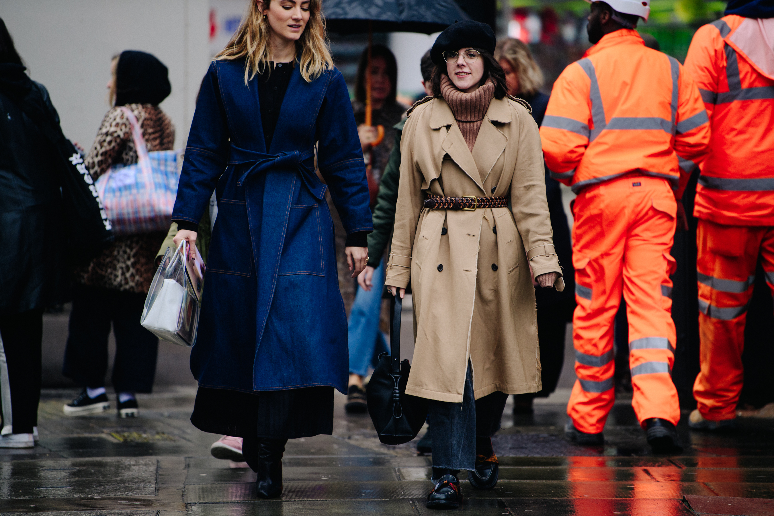 Two women wearing belted coats