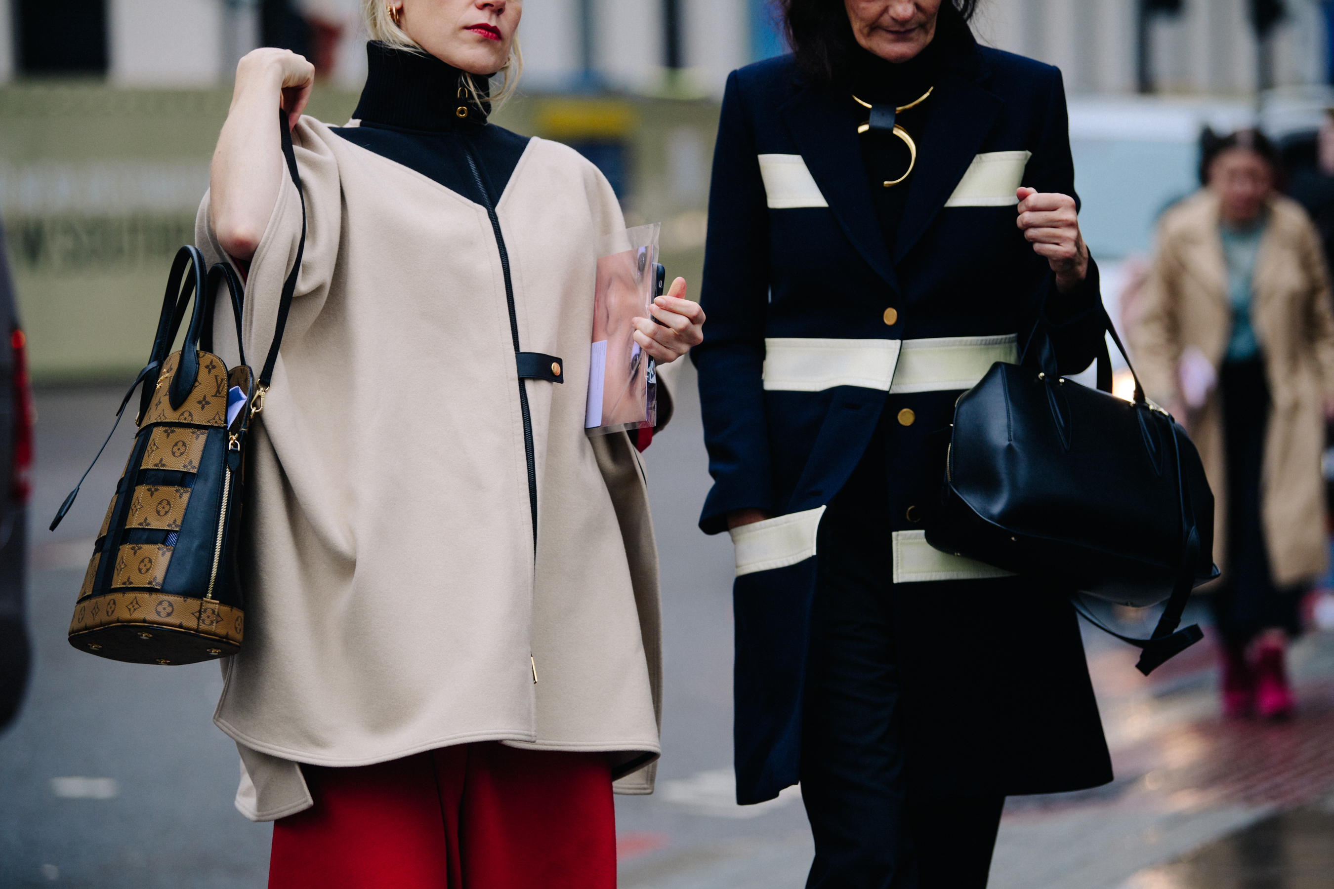 Two women wearing white and black coats