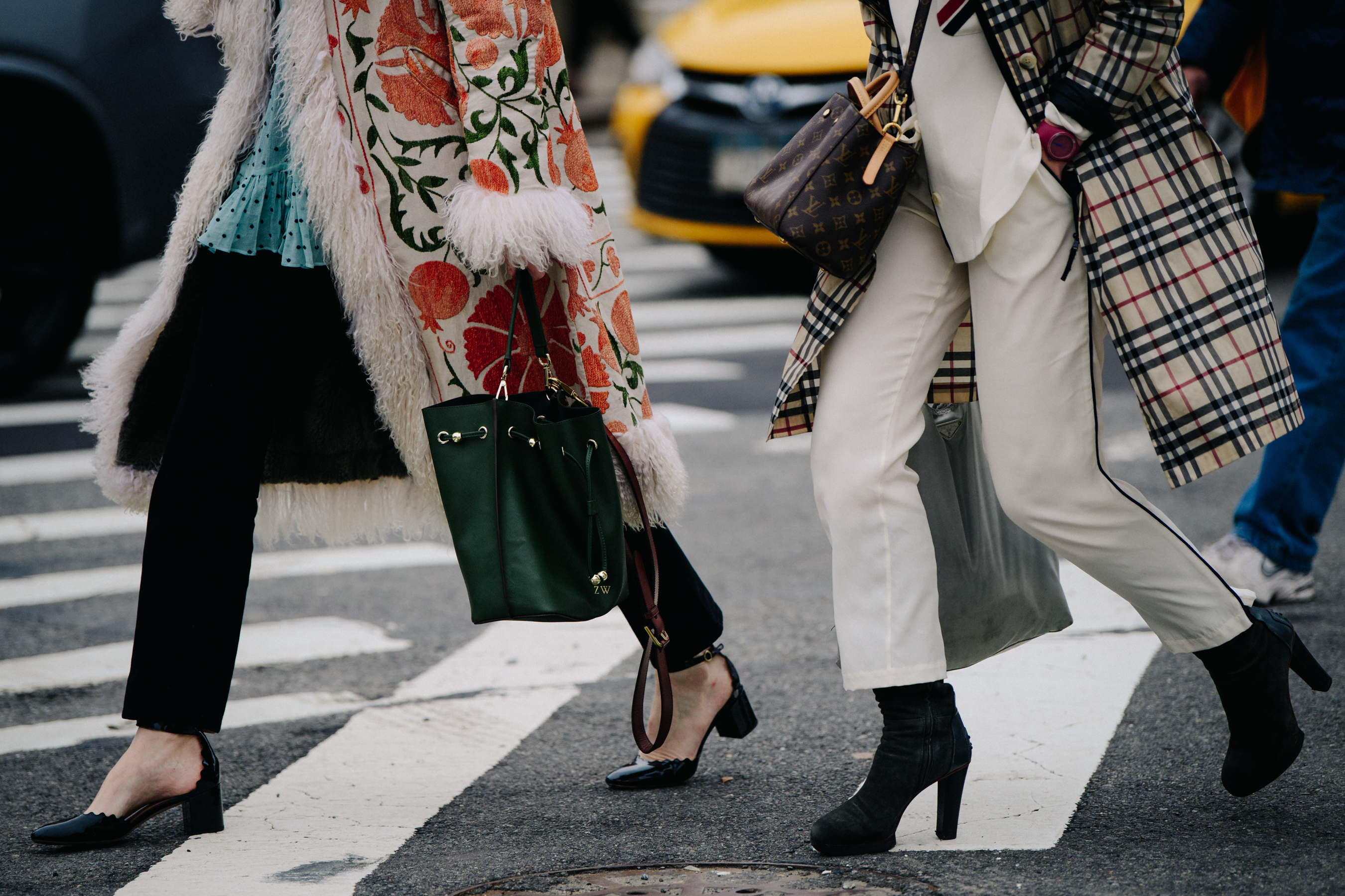 Two women wearing long coats and heels