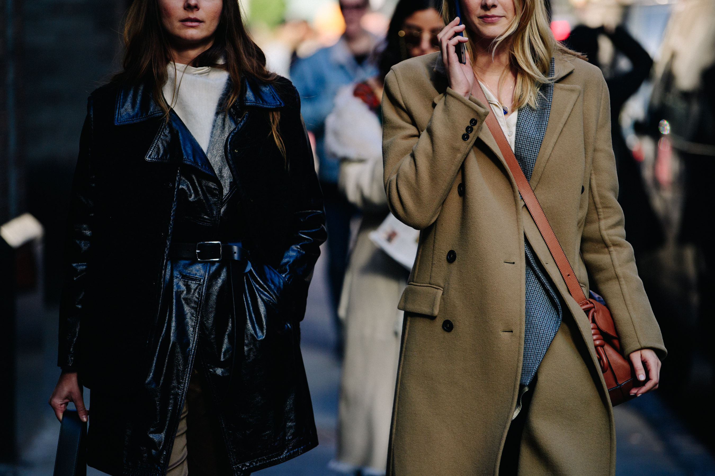 Two women wearing long coats