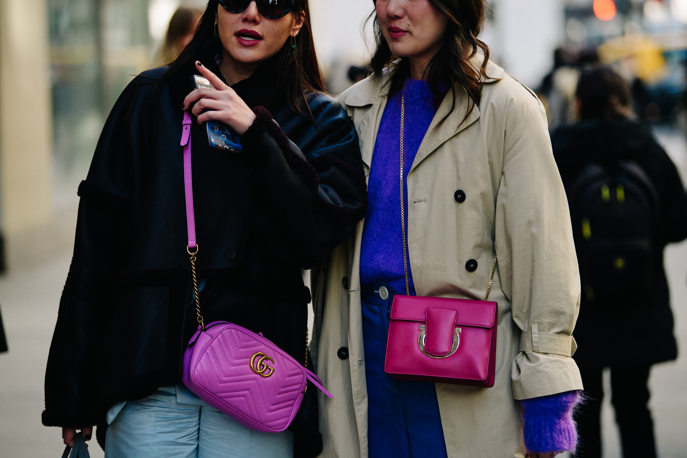 Two women carrying pink bags