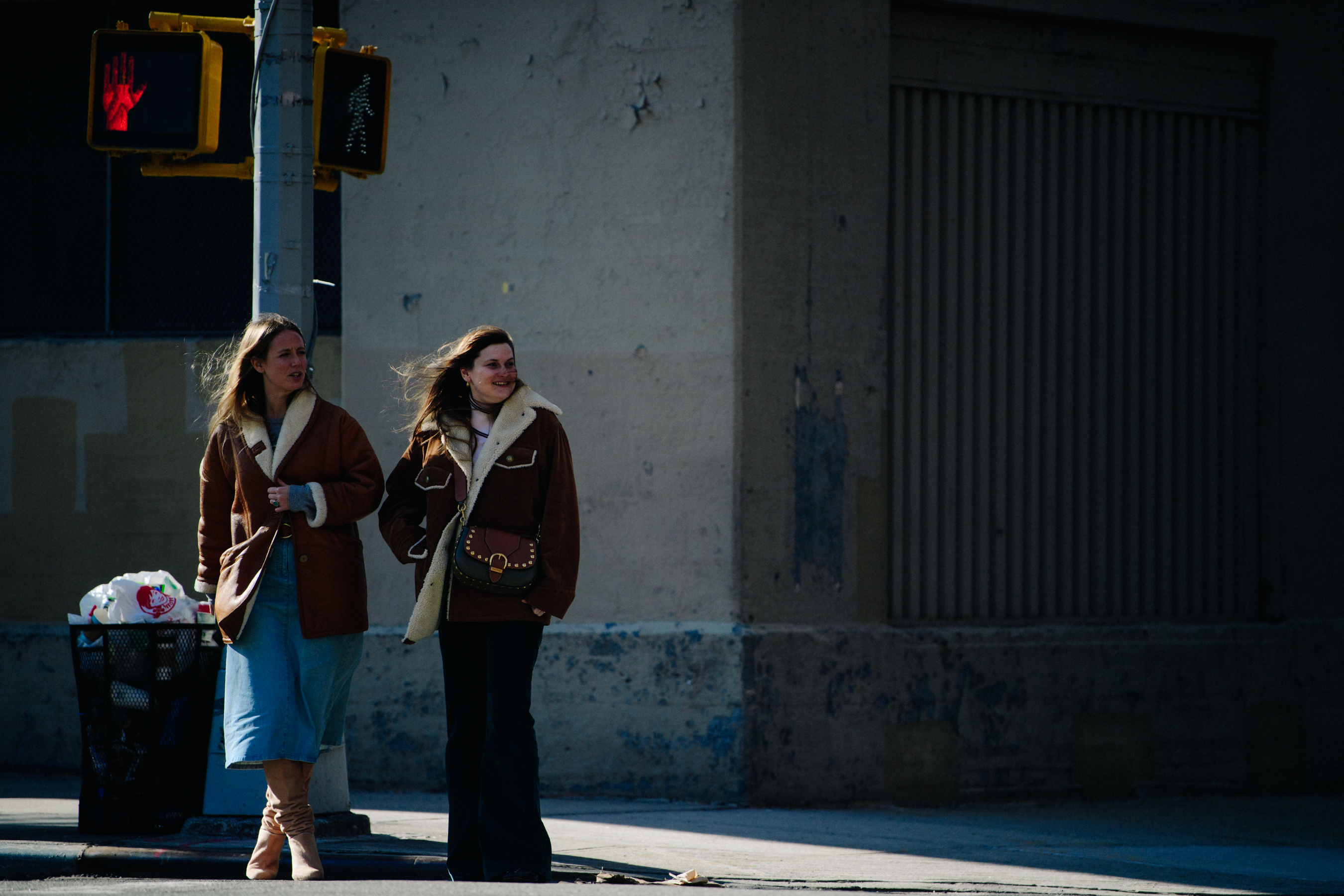 Two women wearing brown shearling jackets