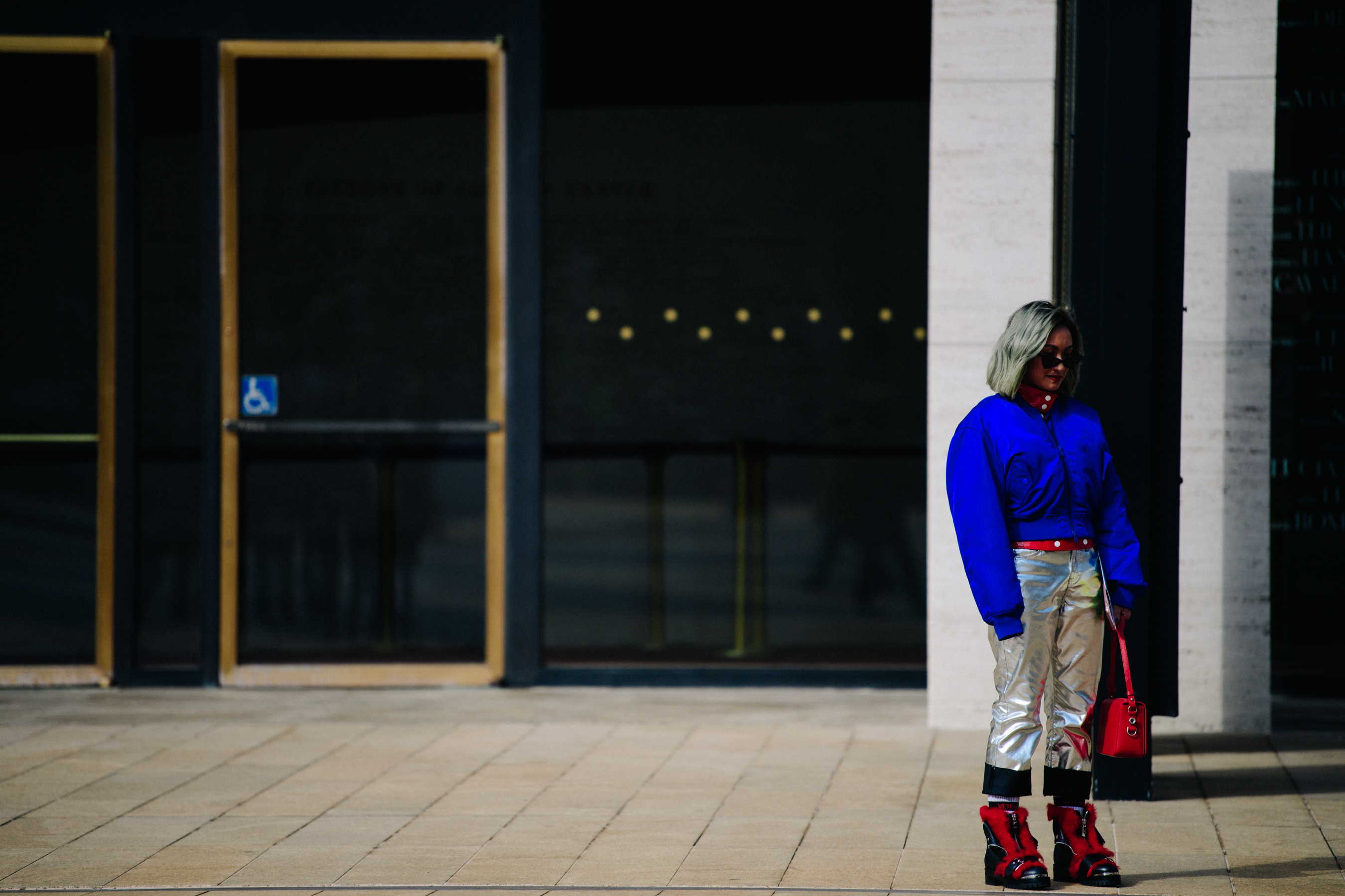 Woman wearing blue jacket and red shoes