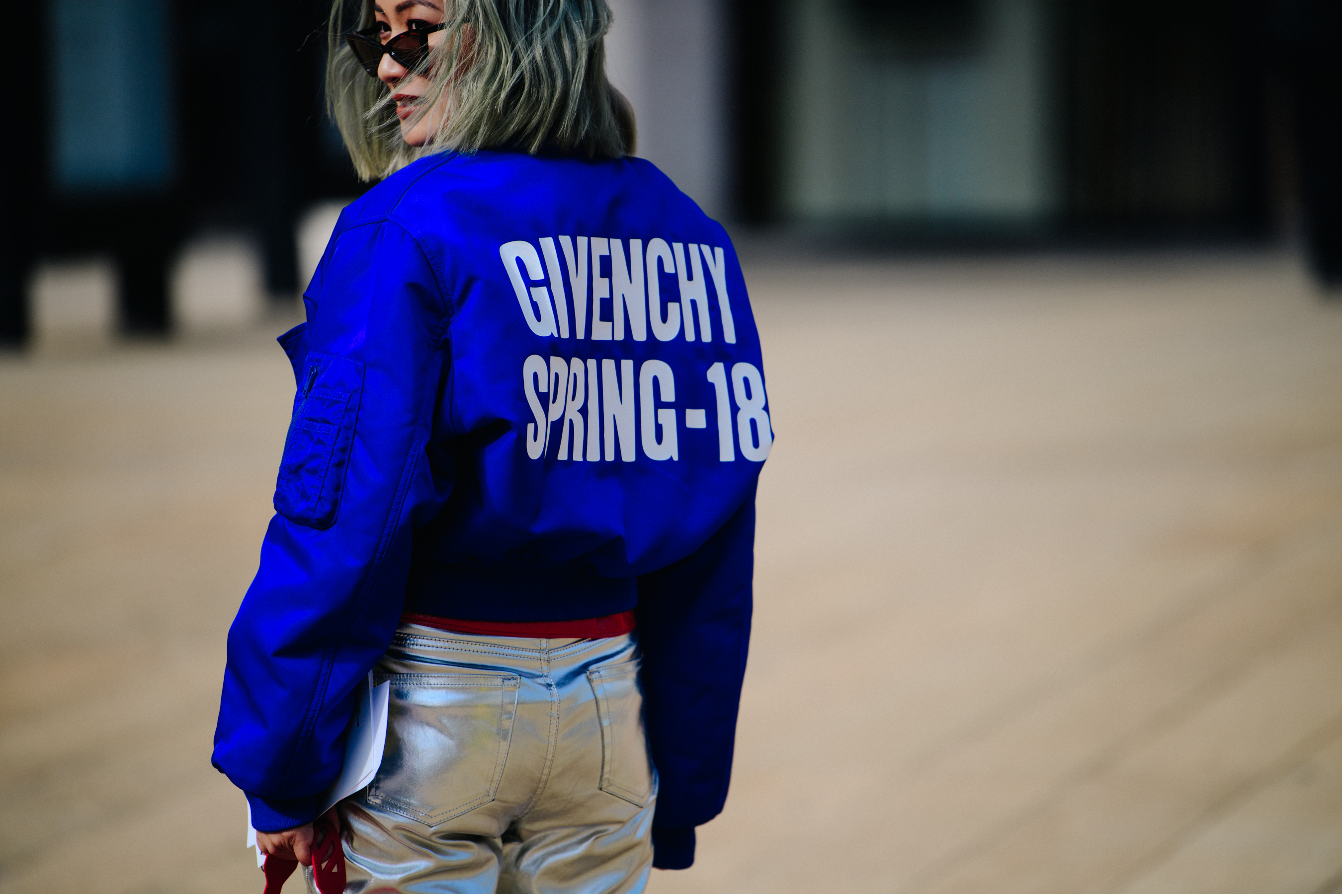 Woman wearing blue jacket and red shoes