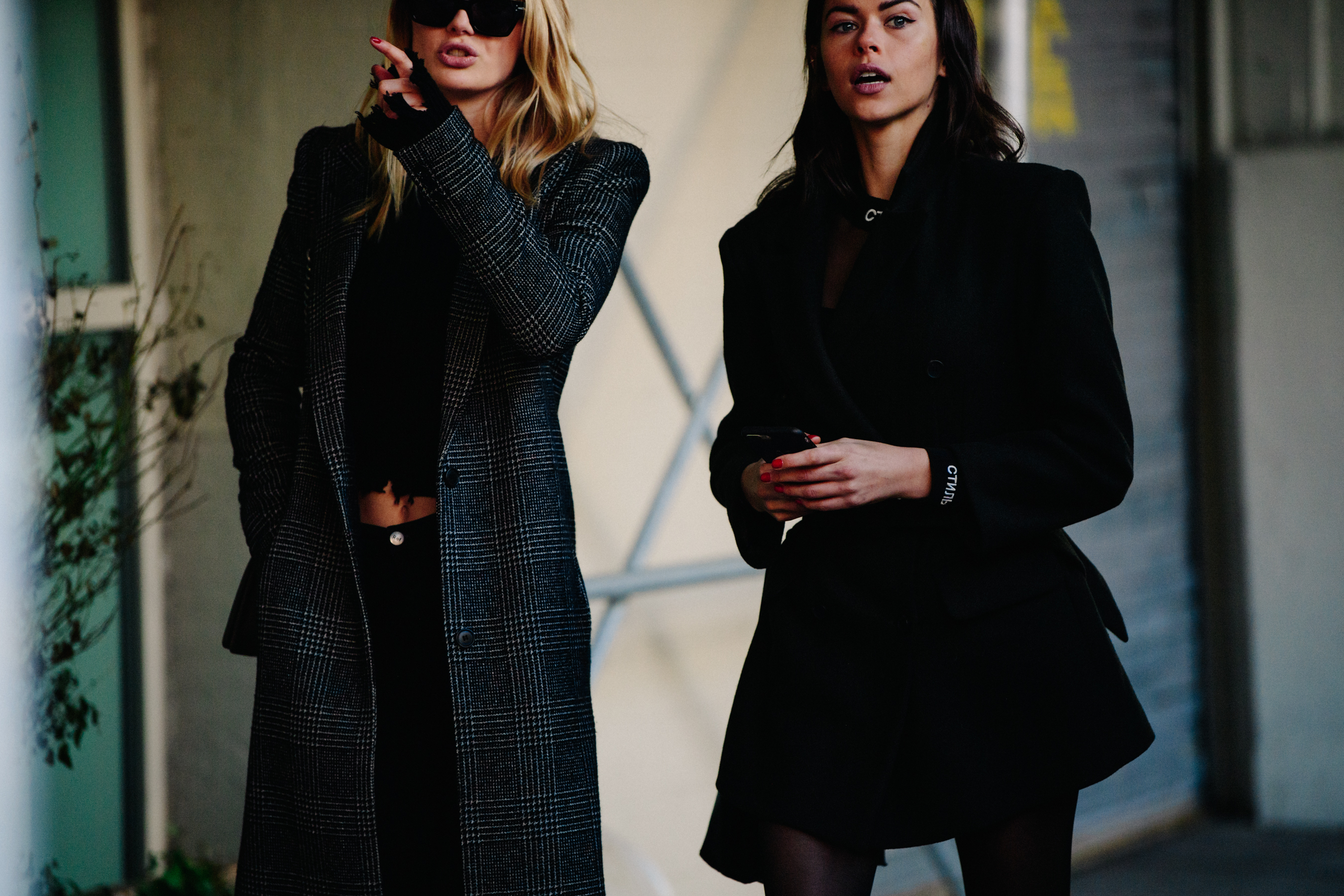Two models wearing dark outfits