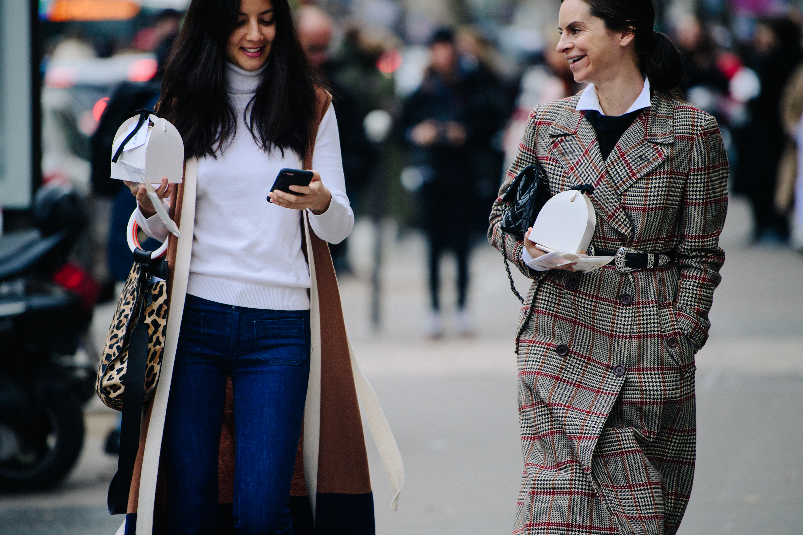 Two women carrying white boxes