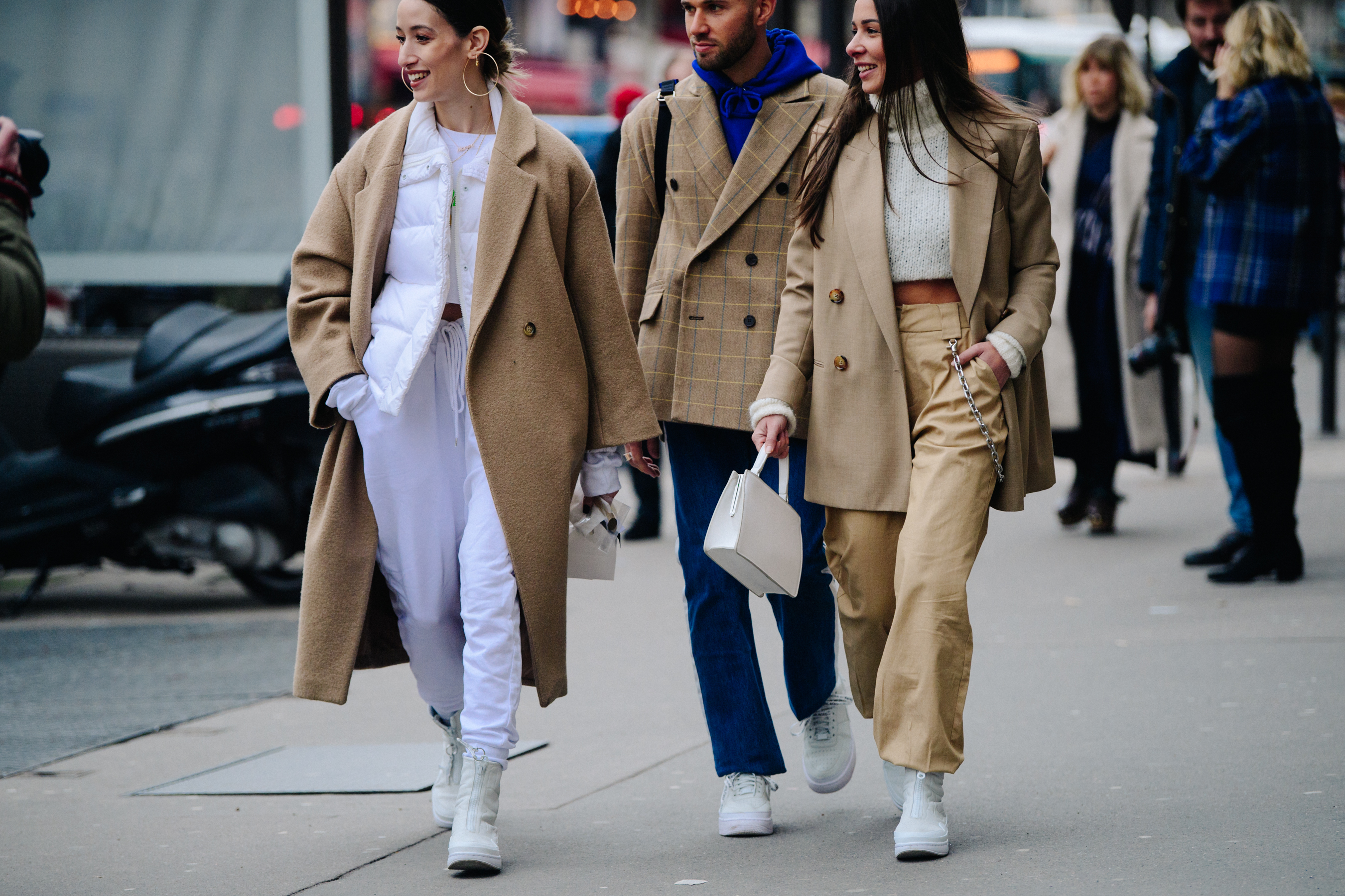 Three people wearing tan coats