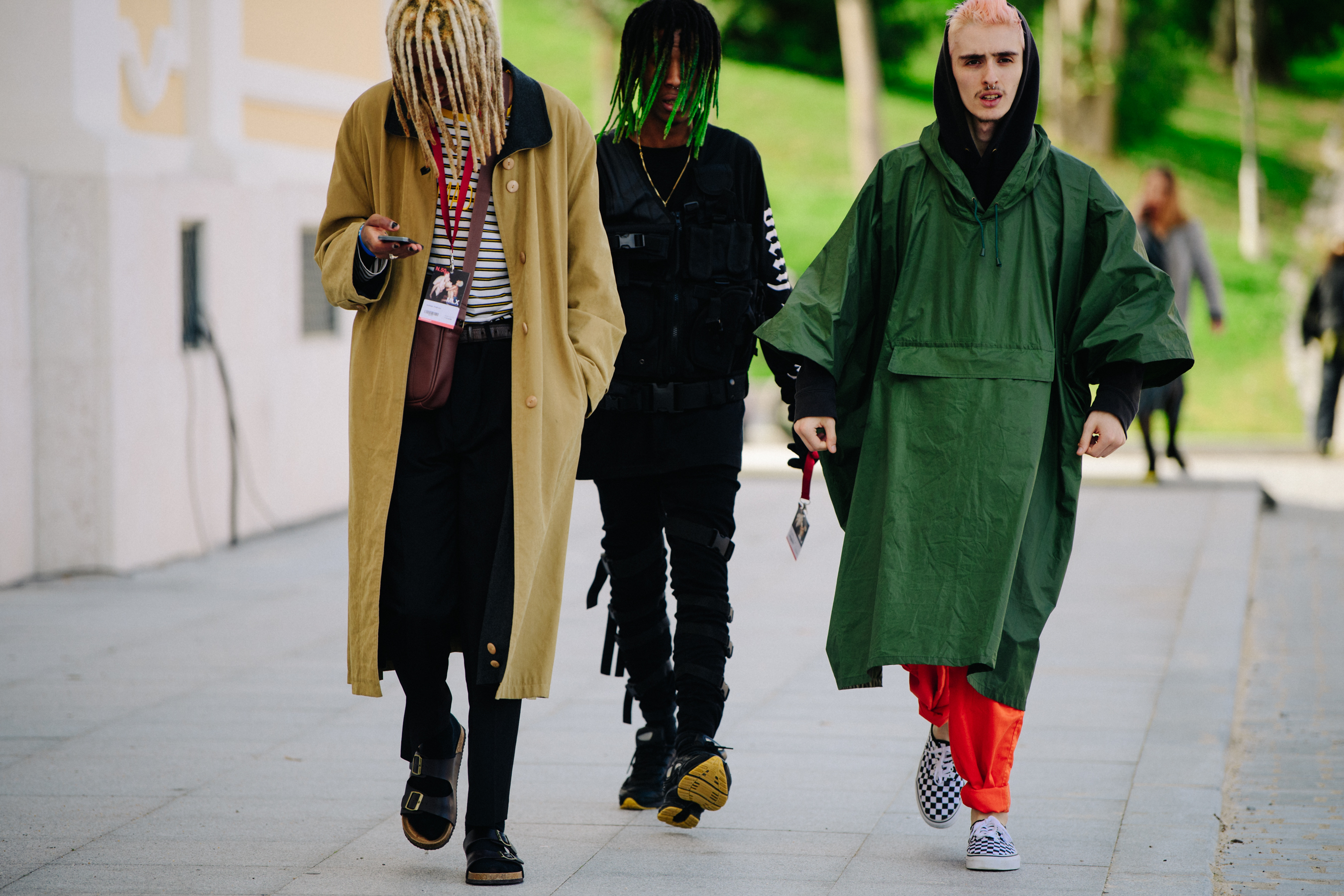 Three men wearing long coats