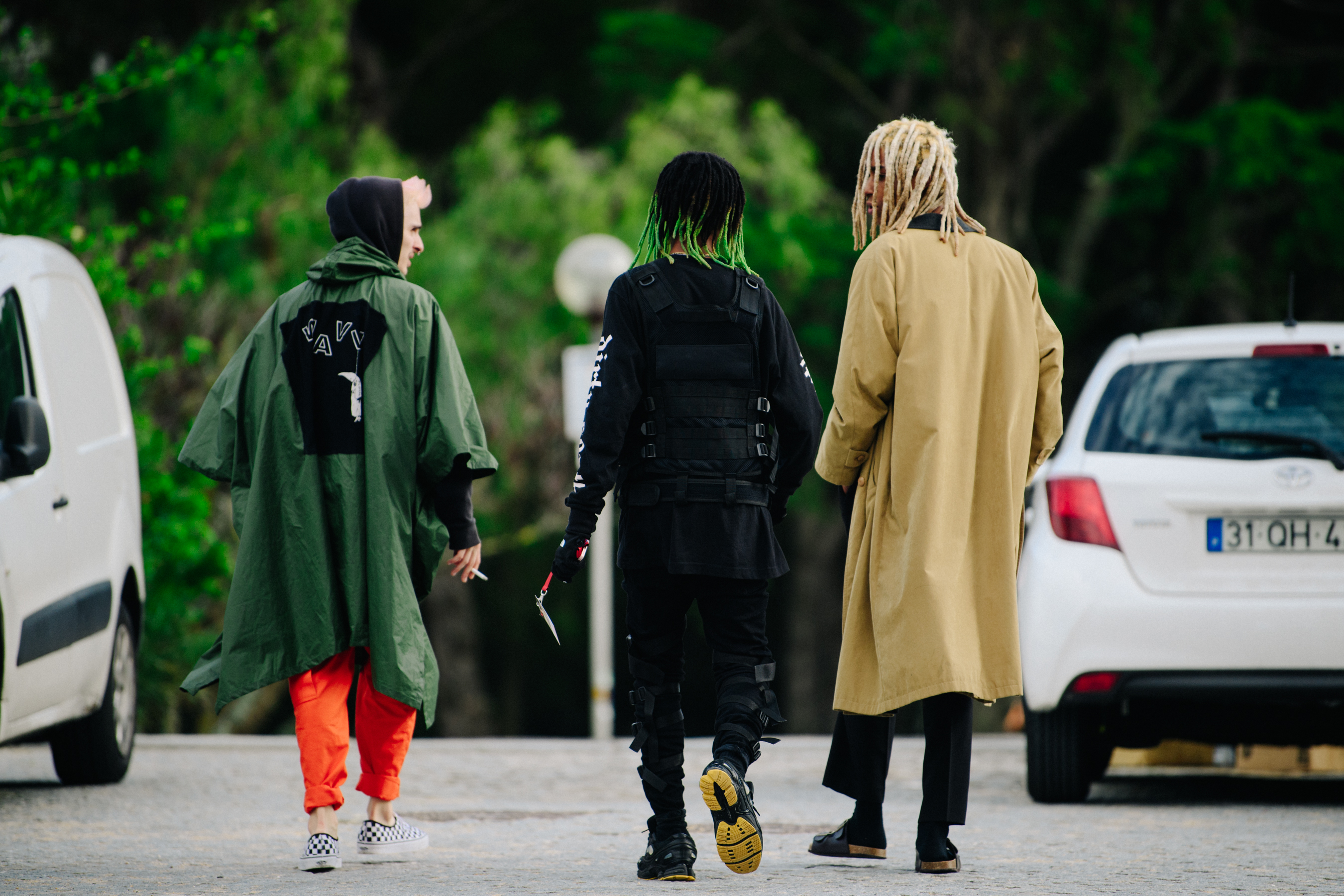 Three men wearing long coats