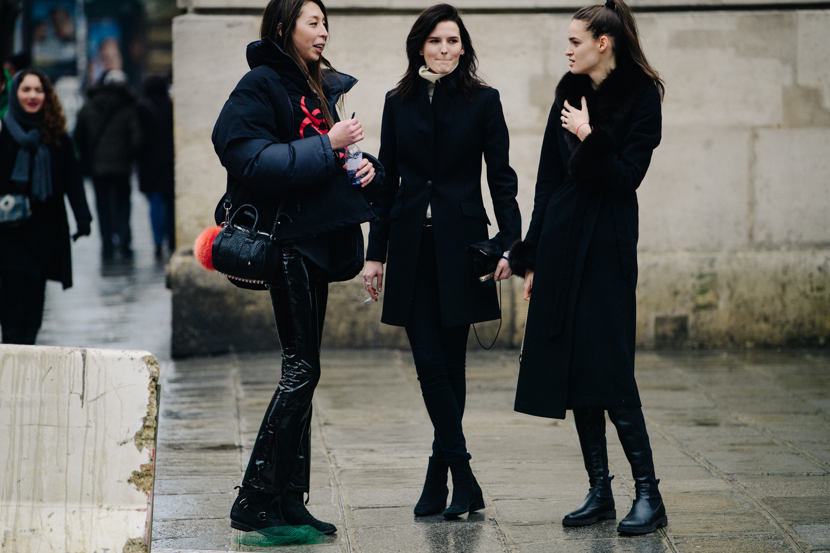 Three models wearing black outfits