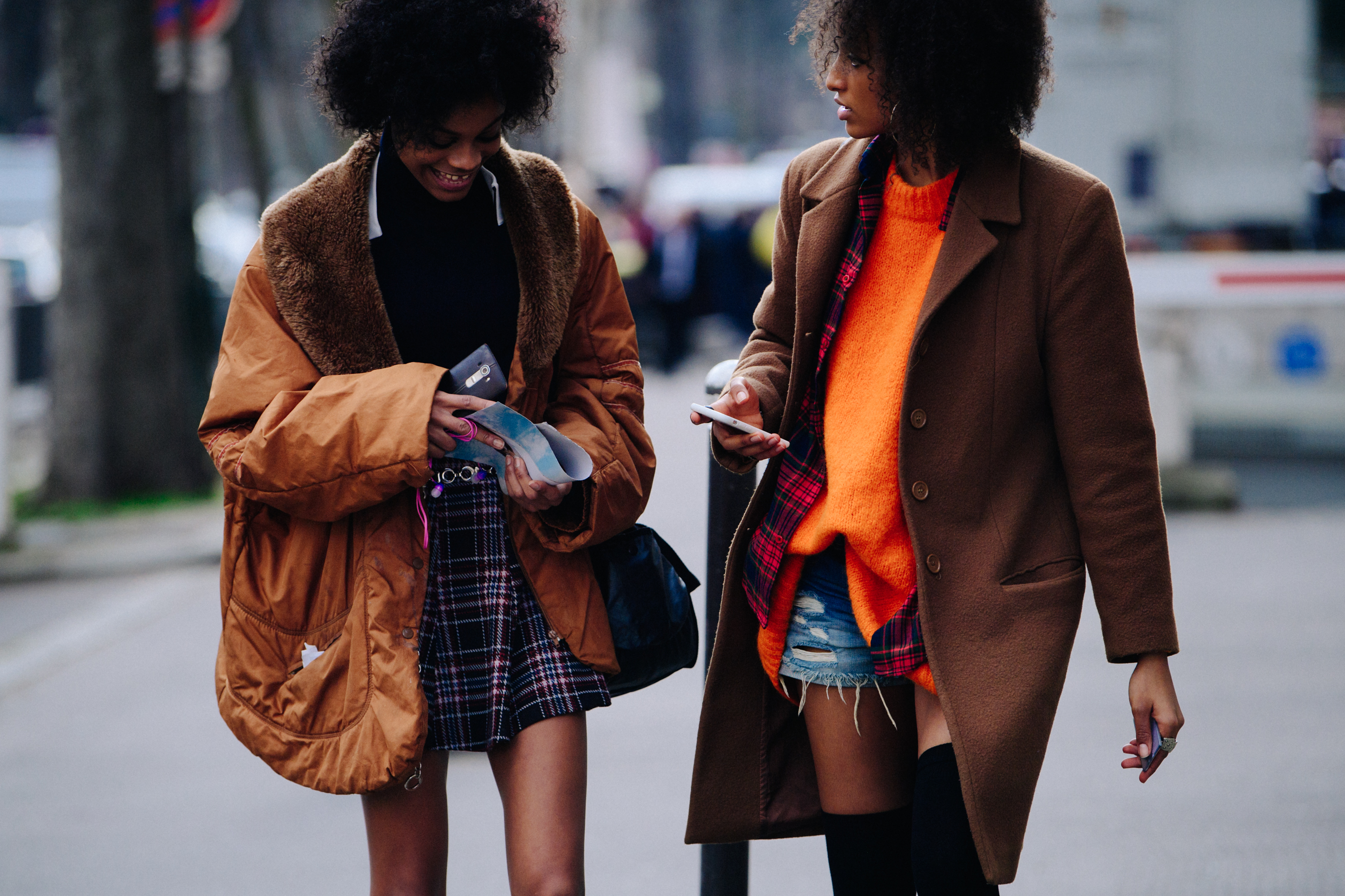 Two models wearing brown coats