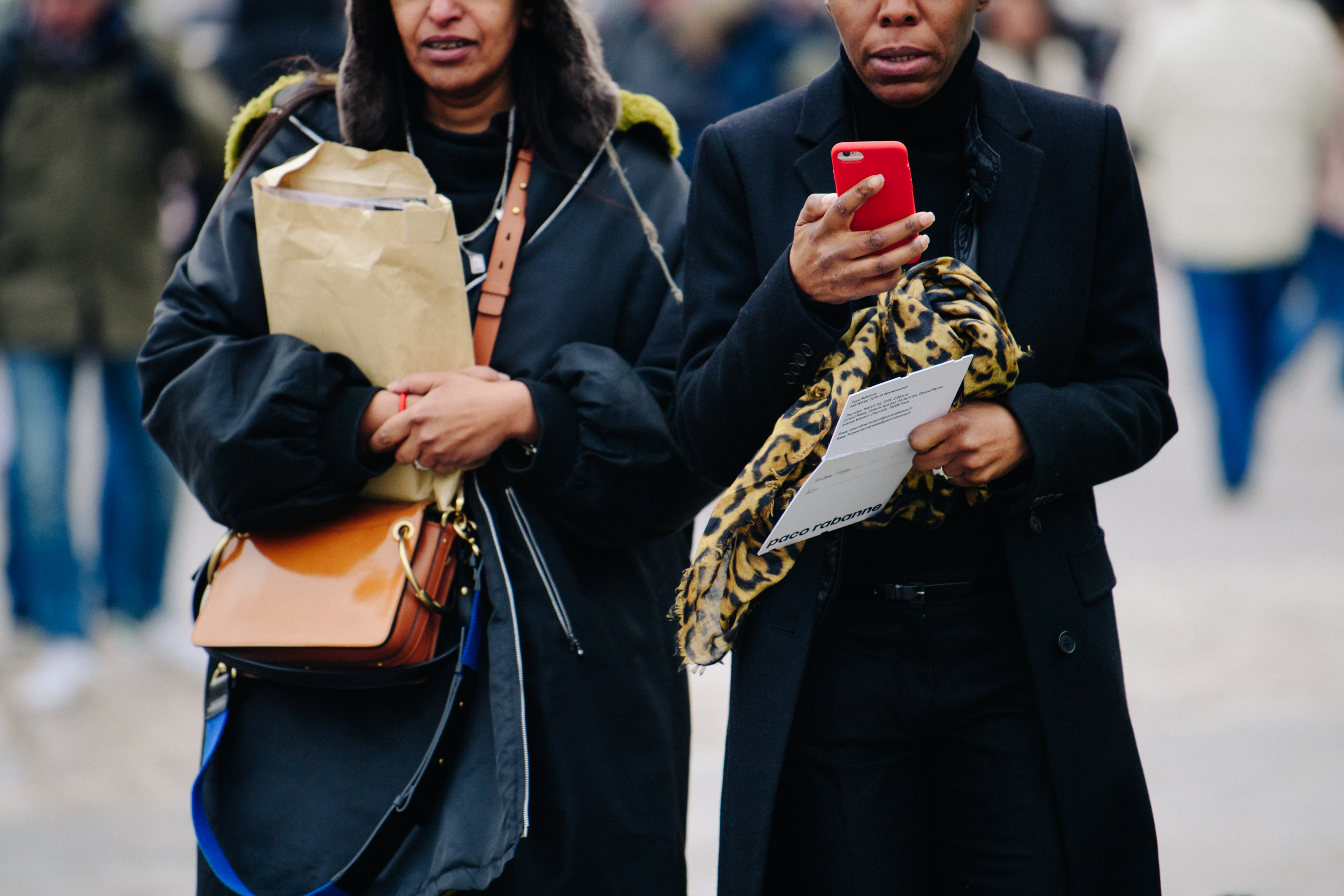 Two women wearing black coats
