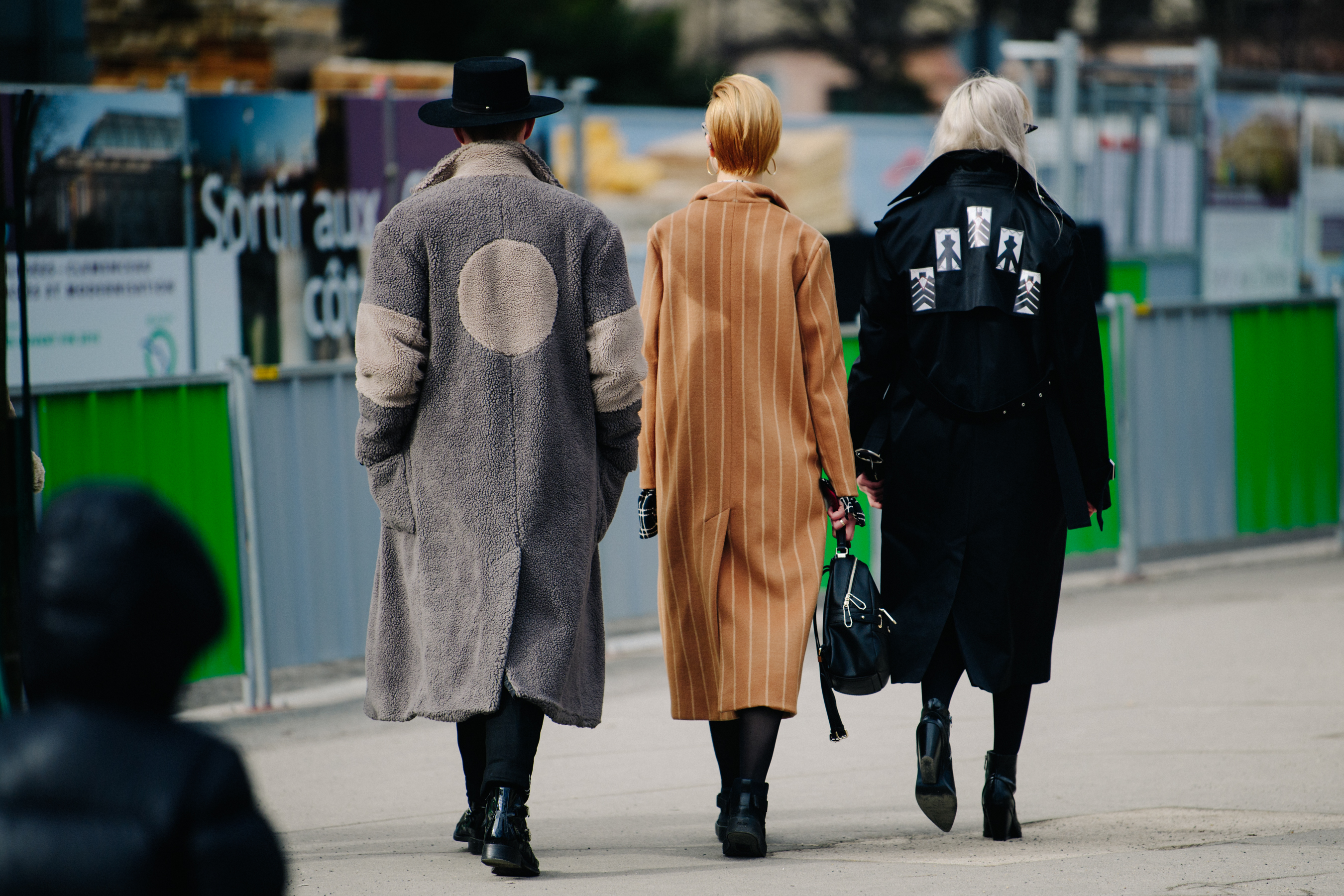 Three people wearing long stylish coats