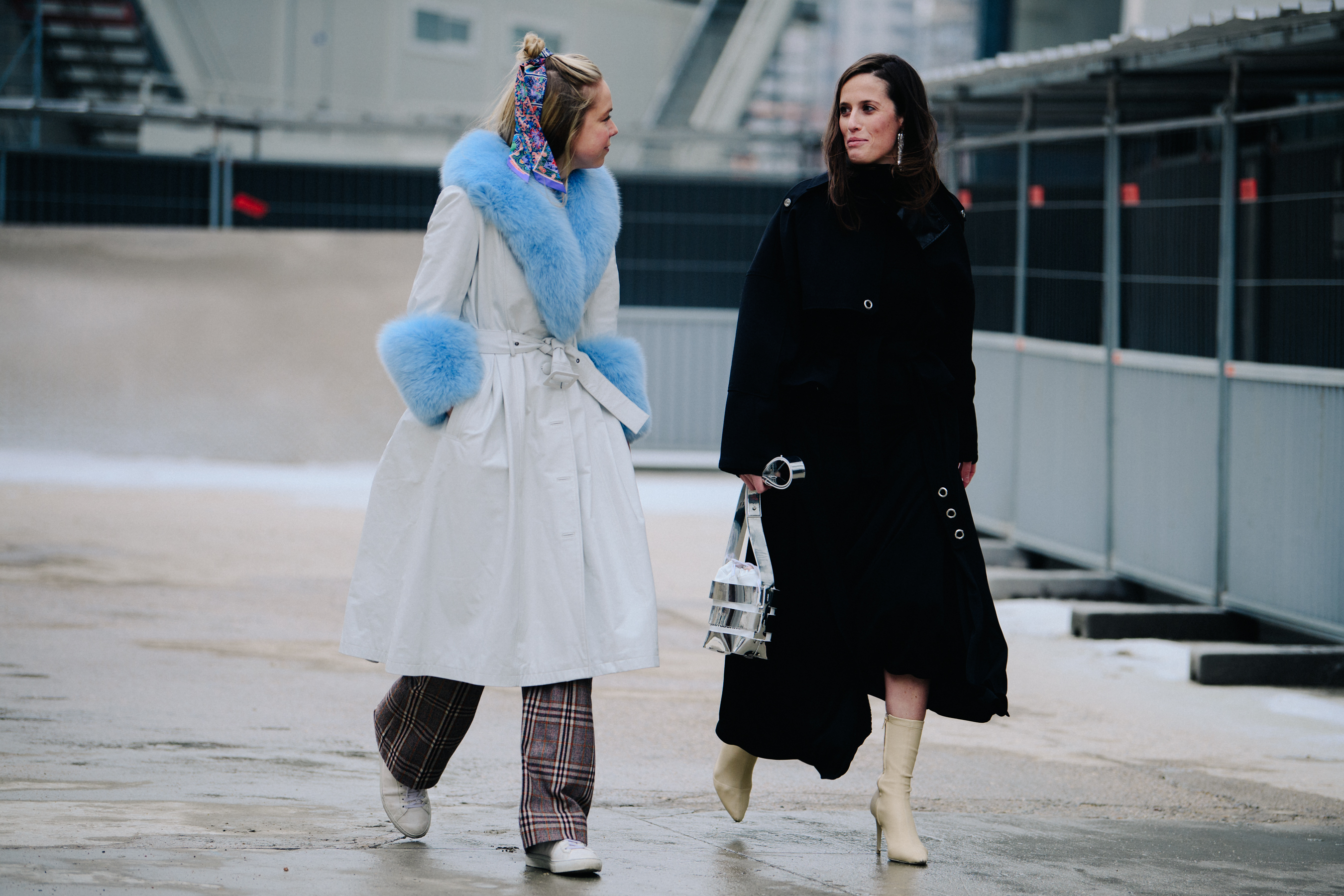 Two women wearing white and black coats