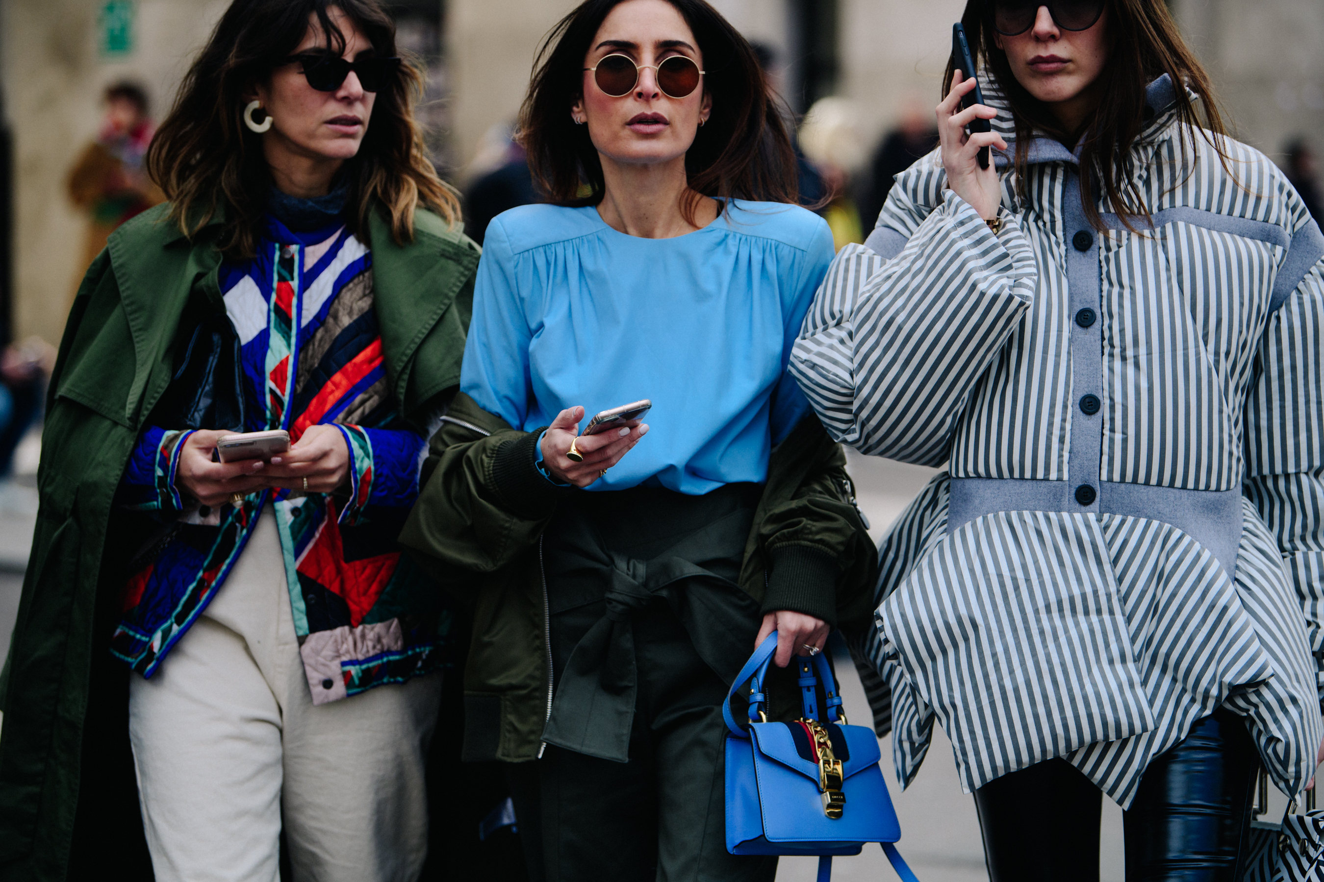 Three women wearing colourful blue outfits