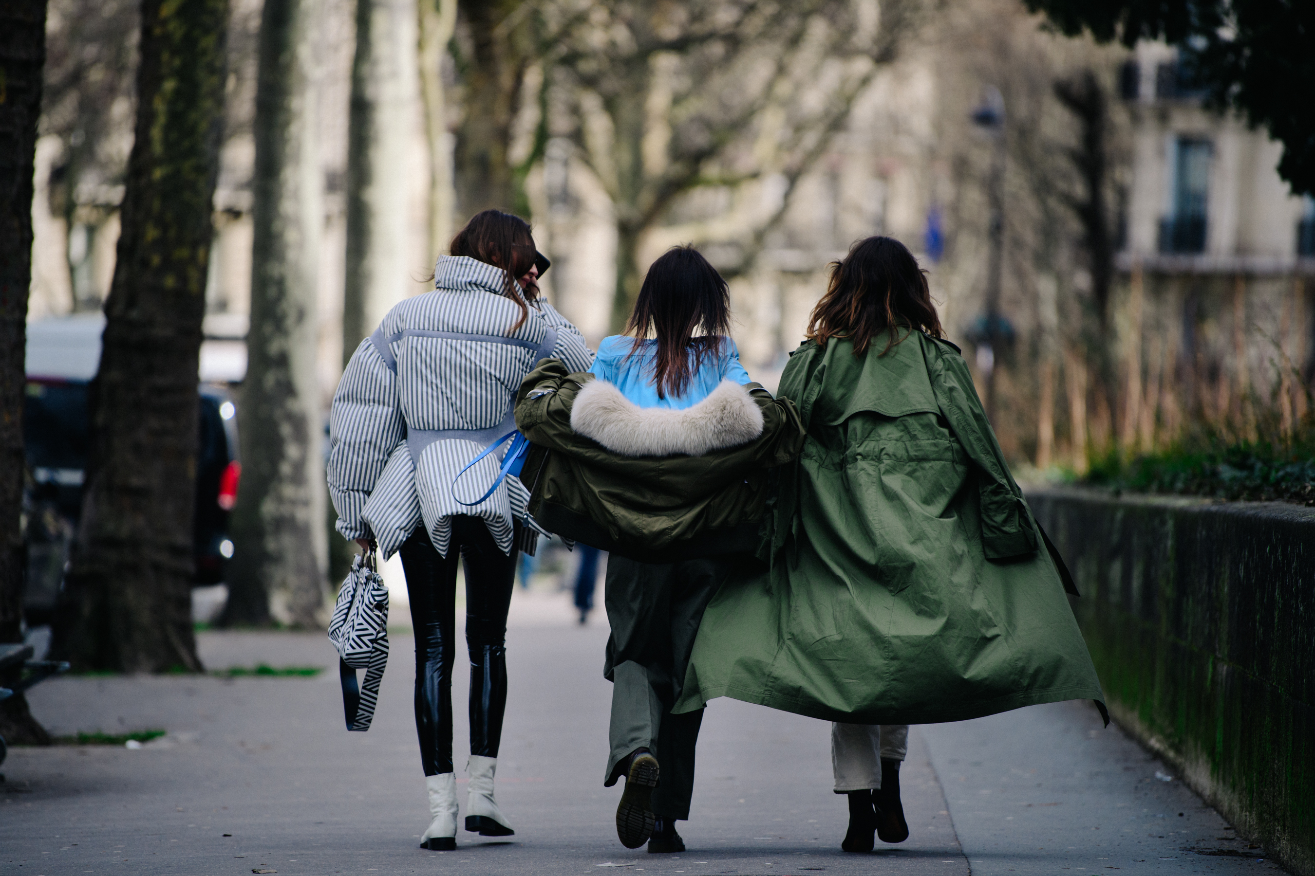 Three women wearing green and blue outfits