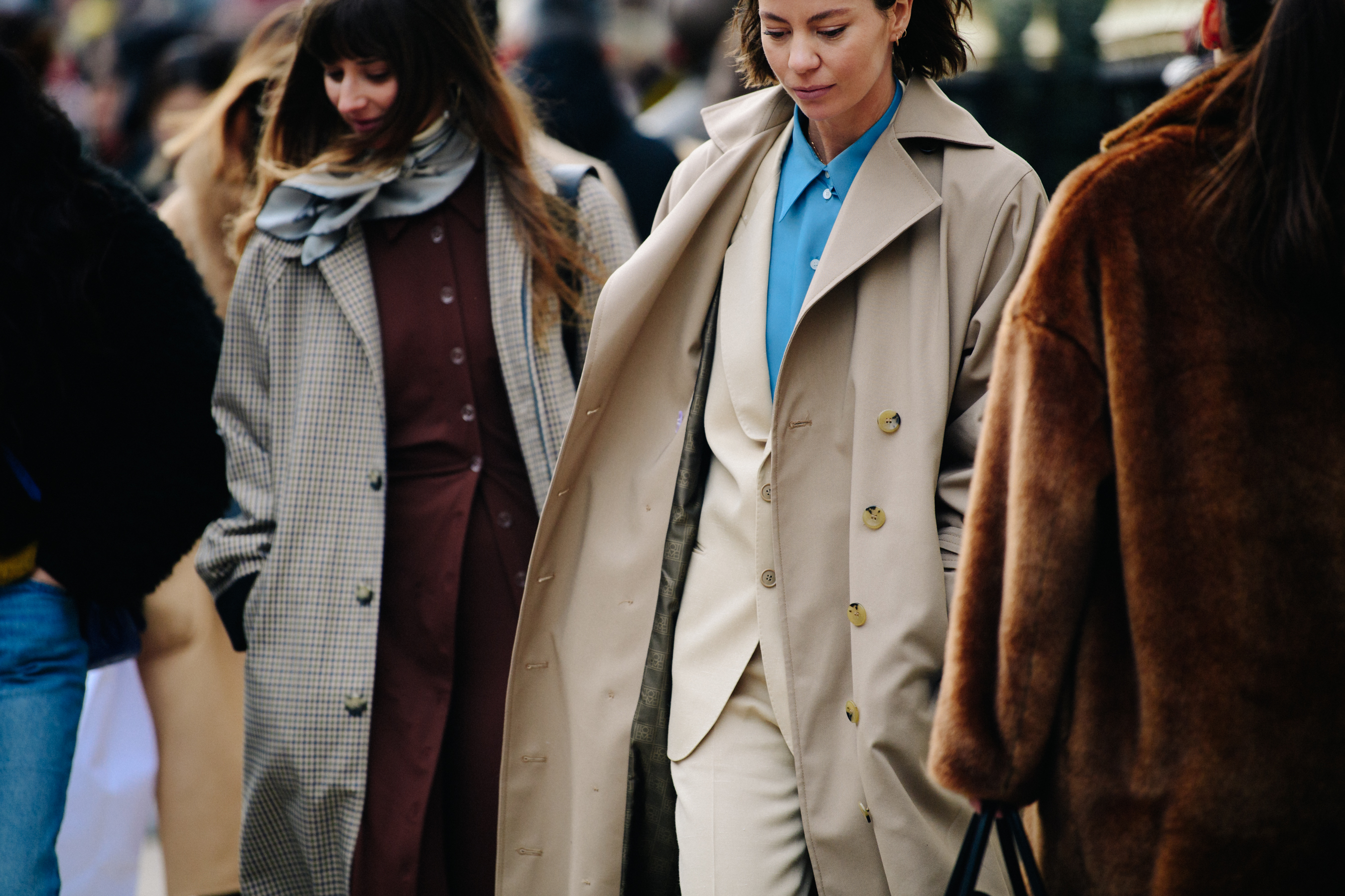 Two women wearing long coats