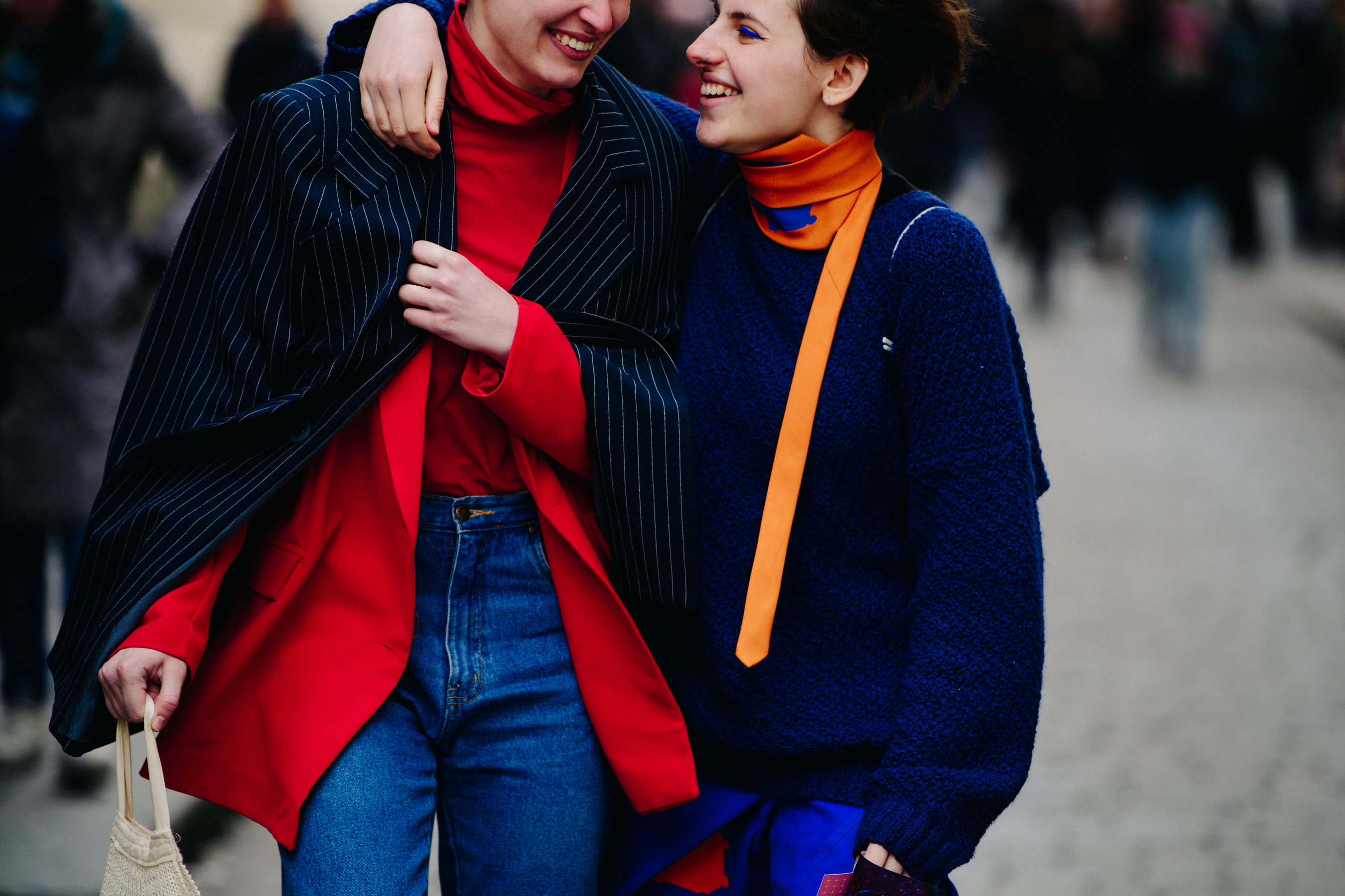 Two women wearing orange and blue