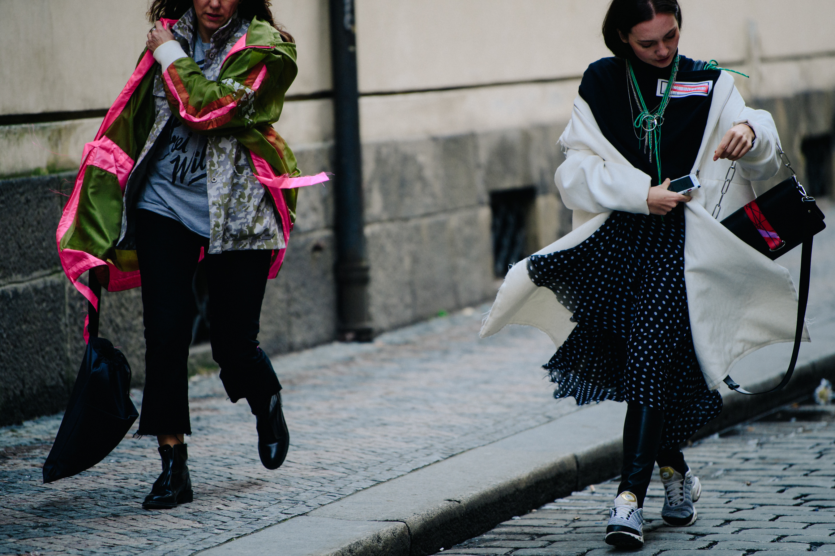 Two women wearing long coats