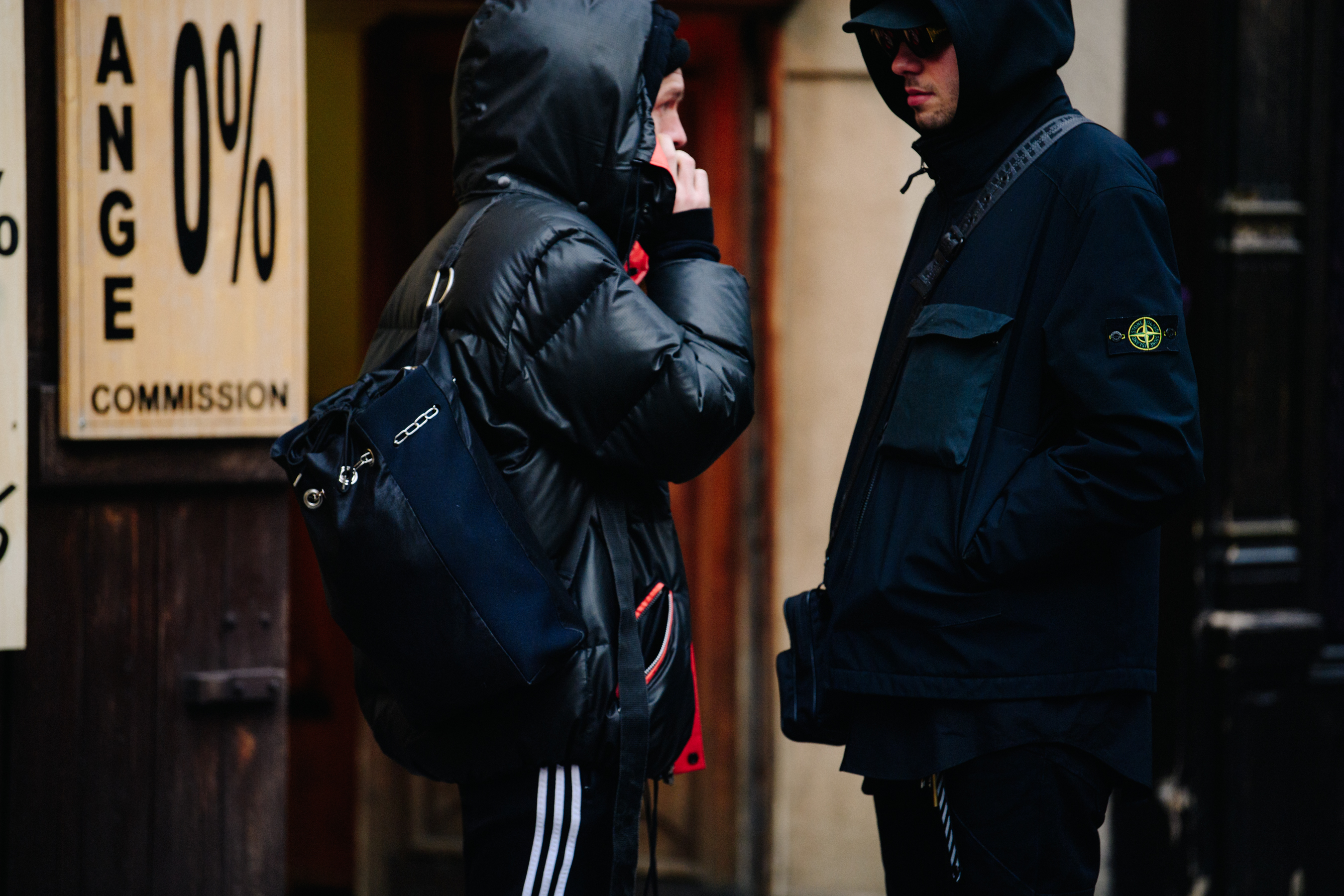Two men wearing dark hoodies