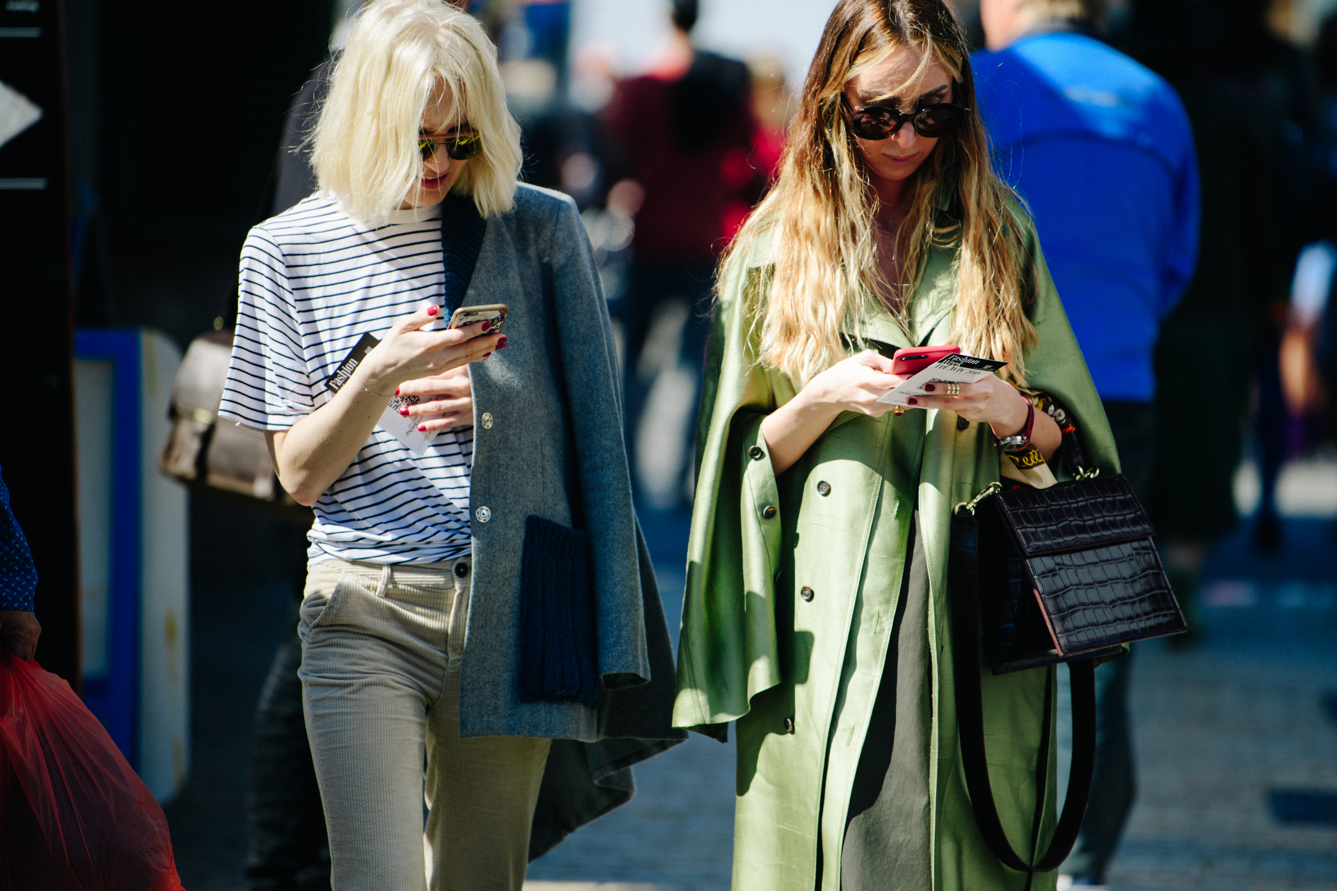 Two women wearing light coats