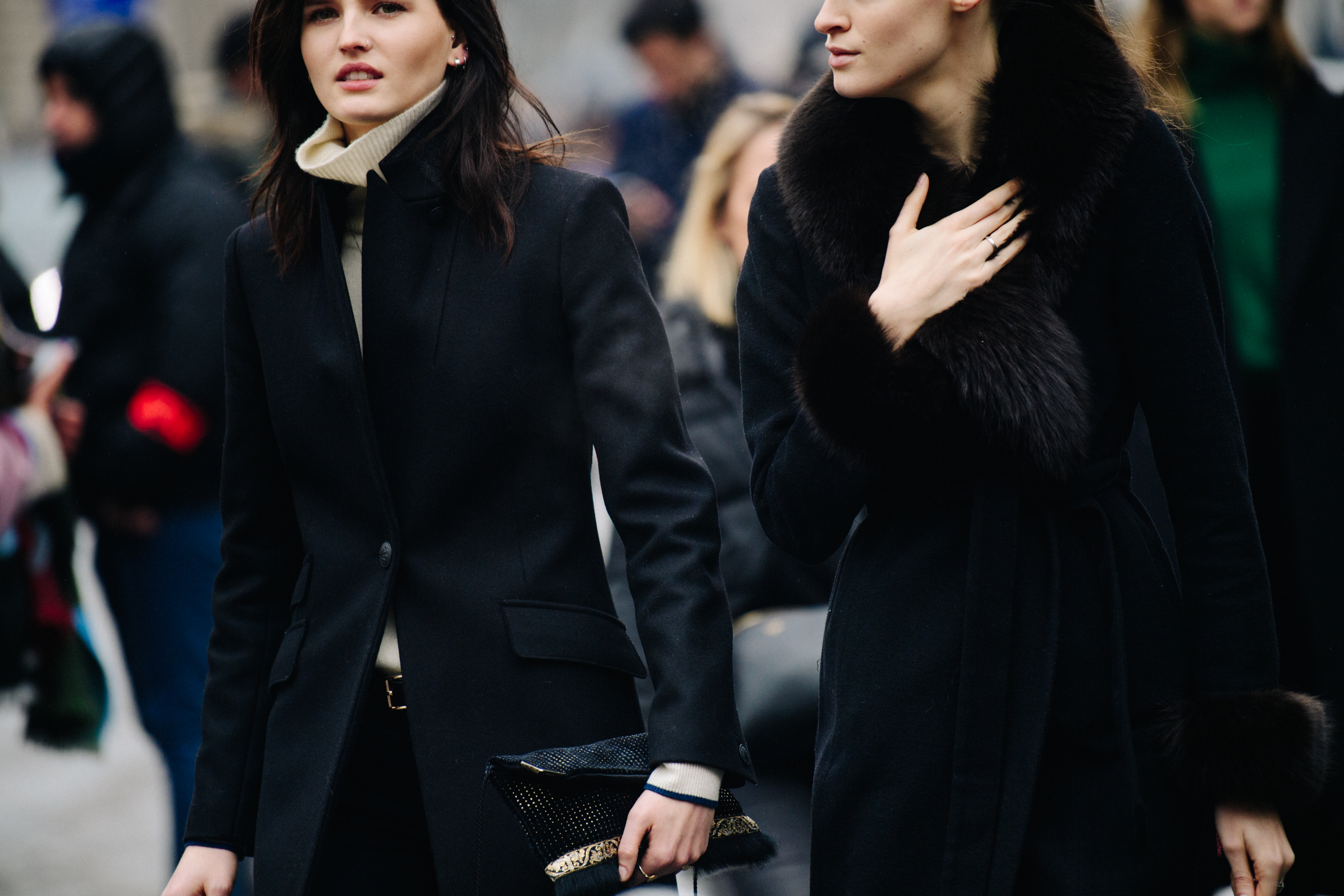 Two models wearing black wool coats
